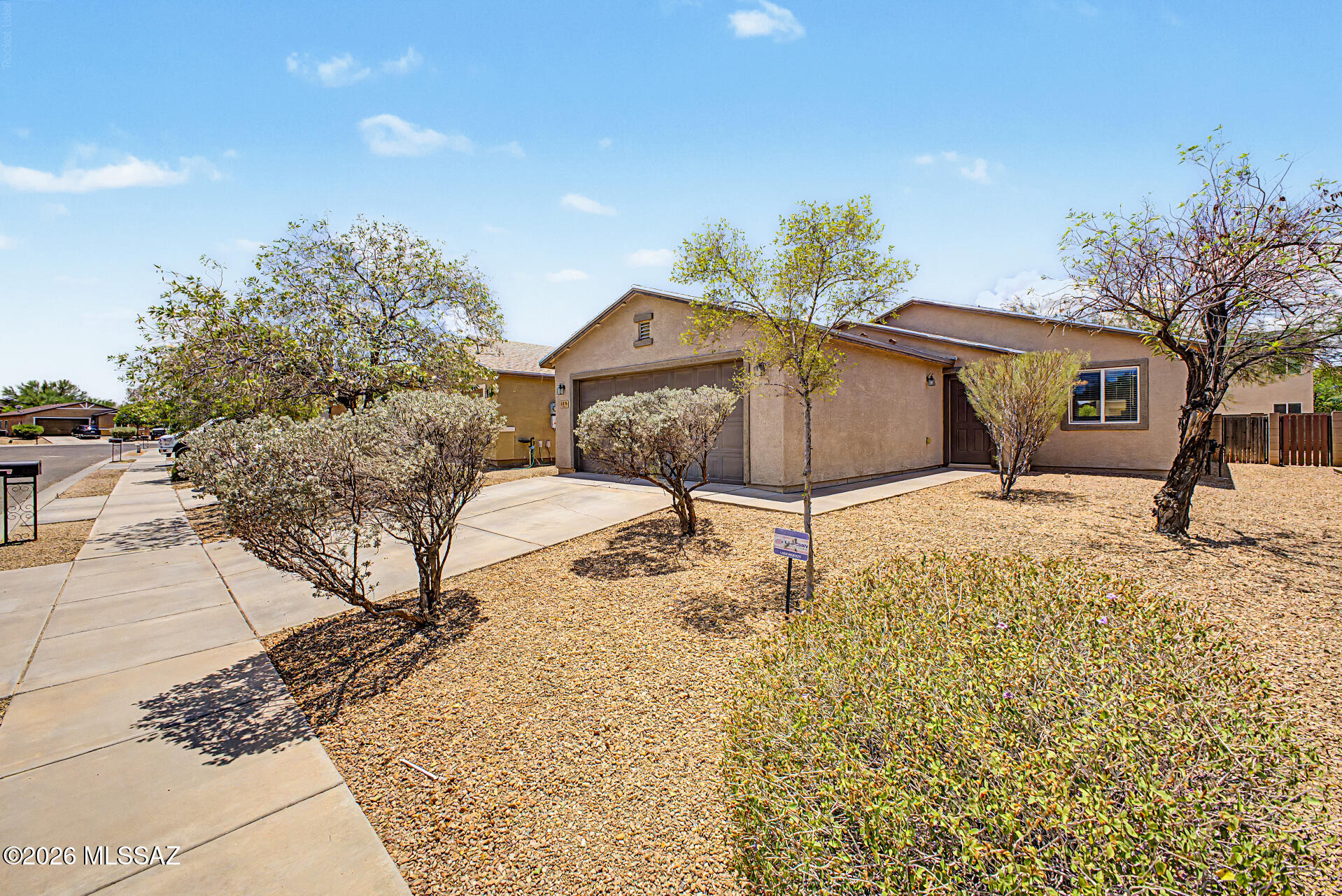 Meticulously maintained and truly move-in ready, this beautiful home is nestled in the highly desirable Rancho Valencia neighborhood. Offering 1,287 square feet of comfortable living space, this 3-bedroom, 2-bath residence features a bright and inviting open-concept great room that is perfect for both everyday living and entertaining. Stylish tile flooring flows throughout the main living areas, while the well-appointed kitchen showcases elegant countertops, sleek black appliances, ample cabinetry, and a large pantry for added storage. The spacious primary suite provides a relaxing retreat with an en suite bath featuring a dual-sink vanity, a convenient shower/tub combination and large closet. Roof replaced in 2024!  All appliances, including the refrigerator, washer, and dryer, plus window coverings are included for effortless move-in convenience. Step outside to a generously sized backyard complete with a covered patio, ideal for outdoor dining or relaxing evenings. Residents enjoy nearby neighborhood parks and an exceptional location just minutes from I-10, Davis-Monthan Air Force Base, Tucson International Airport, shopping, dining, schools, recreation areas, and more!  This is a fantastic opportunity to enjoy comfort, convenience, and pride of ownership in one exceptional home.