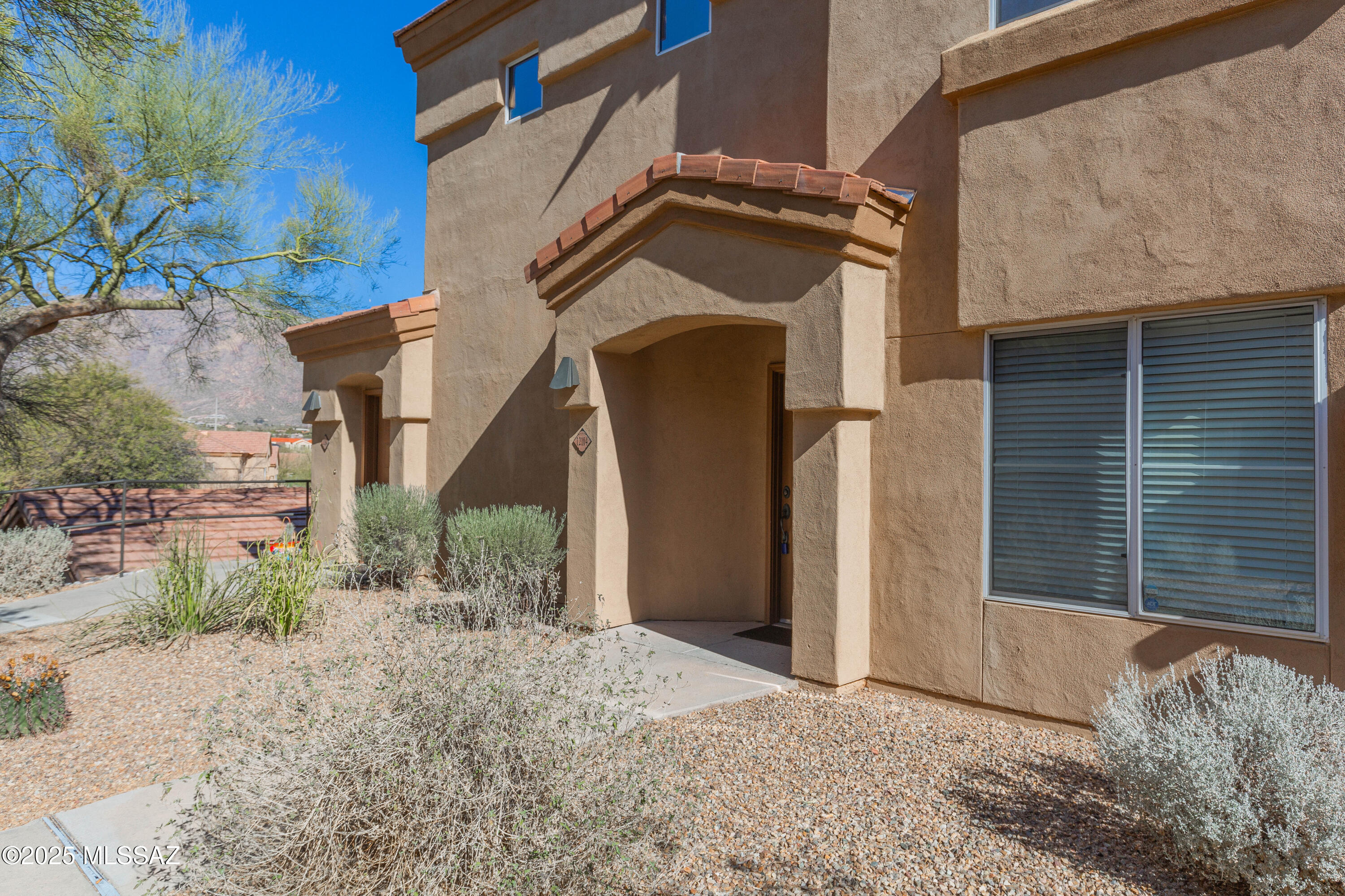 Welcome to this cozy, modern, and meticulously maintained condo! Enjoy breathtaking views of  Tucson's Catalina Mountains from the covered patio, great room, dining area, and kitchen. The fireplace adds a touch of ambiance, and natural light fills every room. This downstairs corner unit features tile flooring throughout, ceiling fans in both the great room and bedroom, and beautiful updates, including matte Quartz countertops, a modern tile backsplash, and stainless steel appliances in the kitchen. The bathroom is also updated for a contemporary feel. With a new HVAC system installed in 2020, this home is ready to move in. Located in a prime spot, the HOA covers amenities like the pool, spa, fitness center, clubhouse, security, gated community access, and trash/recycling services...