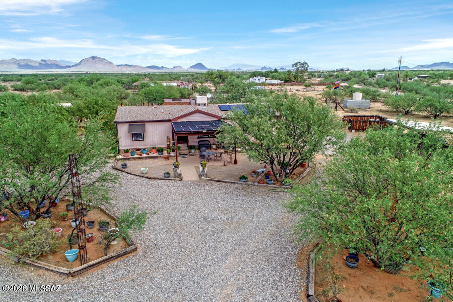This property has a little bit of everything, over 4 acres of fenced land, nice 3 bedroom 2 bath 2004 built home, carport, multiple outbuildings, greenhouse, and corrals for goats or pigs. Nicely landscaped with raised beds. Patio in back has a hot tub. Patio in front has great sunset views. Seller owned solar panels on home. Roof replaced in 2019 before solar installed. Newer flooring. HVAC was replaced in 2013. Water heater about 5-6 years old. This property has a septic system and is on a 4 person shared well. This property has a western village look to it with the design of the buildings. Very nice property located just off Sandario. Not on a long dirt road.