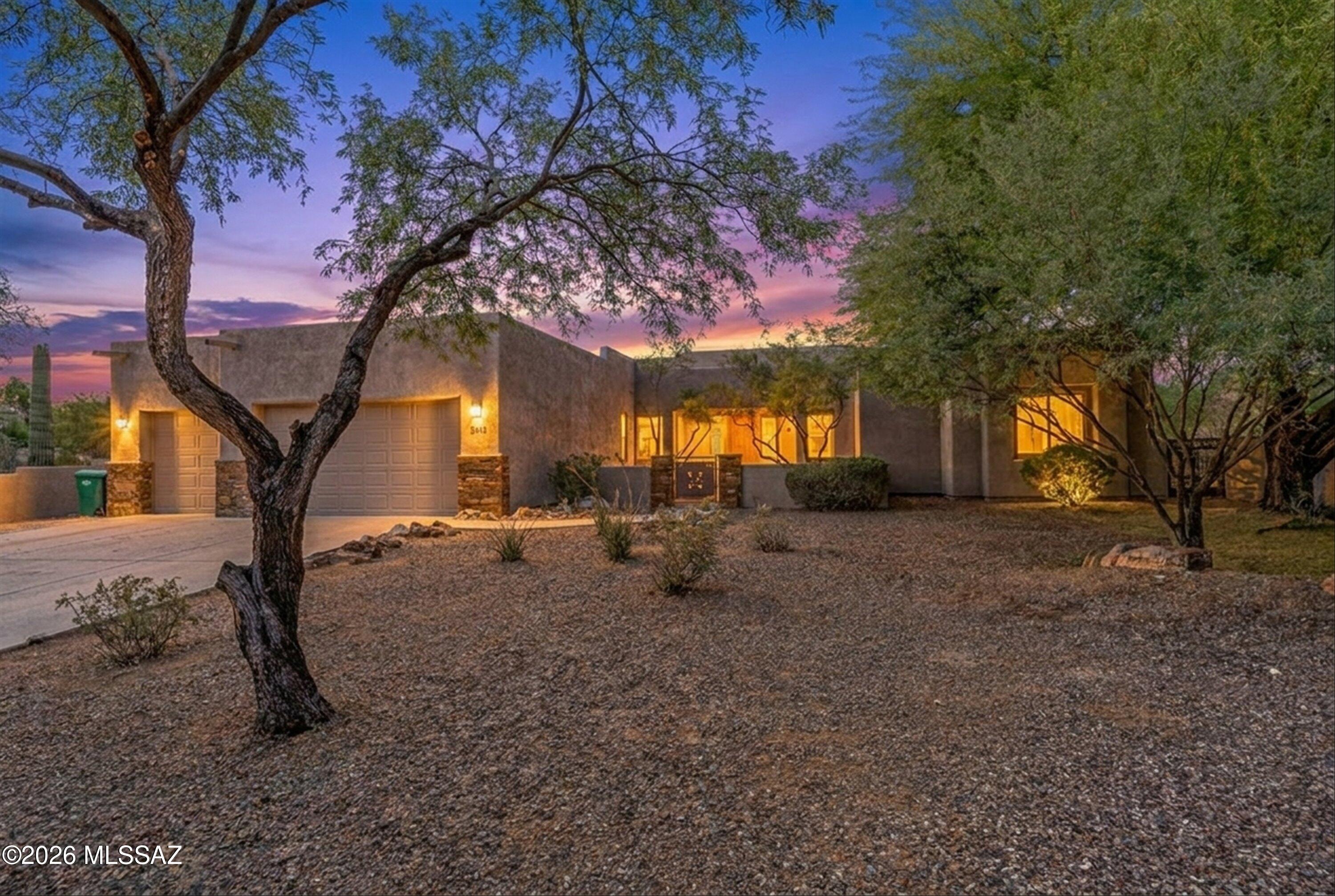 Presented by Northwest Tucson's premier luxury specialists, this gated Haciendas De La Carolina custom estate is one of the most compelling offerings in today's market. Positioned on a cul-de-sac lot and set on nearly an acre, this single-story 4BR/3BA residence delivers a rare combination of privacy, scale, and resort-style living -- all framed by Catalina Mountain views.
What truly sets this property apart is the lifestyle it offers -- a backyard designed to rival a private resort and a floor plan built for both everyday living and entertaining.
At the heart of the home, the kitchen serves as a natural gathering space. Featuring knotty alder cabinetry with crown molding, granite countertops, a large center island with gas cooktop, stainless steel appliances, and a custom tile backsplas it delivers both function and presence. An eat-in breakfast nook surrounded by windows brings in natural light while framing views of the backyard and mountains beyond. The kitchen flows seamlessly into the family room and outdoor living areas, creating the kind of connectivity buyers are searching for.
Designed with a split-bedroom floor plan, the layout offers ideal separation between the primary suite and secondary bedrooms, while multiple distinct living spaces provide flexibility. A formal living room anchored by a dramatic floor-to-ceiling travertine fireplace creates a striking focal point, while the separate family room opens directly to the kitchen and backyard. A dedicated formal dining area completes the home's ability to entertain with ease.
The primary suite is thoughtfully positioned as a private retreat, generously sized with direct backyard access and a spa-style bath featuring a circular soaking tub, dual vanities, and a walk-in shower. The oversized walk-in closet provides ample storage. Secondary bedrooms are all well-sized with walk-in closets, and the flexible layout allows space for guests, work-from-home, or additional living needs. A full laundry room with cabinetry, counter space, and utility sink adds everyday convenience.
And then -- the backyard.
Designed as a true extension of the home, this outdoor space delivers an experience rarely found at this level. A freeform pool with natural boulder accents creates an organic desert aesthetic, while the elevated spa is positioned to take in Catalina Mountain views. Multiple gathering spaces are thoughtfully integrated throughout, including a covered patio, a stone-column gazebo with fireplace, and a glass fire pit with built-in seating.
A built-in BBQ supports effortless outdoor entertaining, while the private putting green and expansive yard space offer recreation and flexibility that set this property apart. Evening lighting enhances the entire setting, creating a striking ambiance after sunset.
A welcoming courtyard entry introduces the home, complemented by stacked-stone architectural accents and mature desert landscaping including towering saguaros. The extended driveway and 3-car garage enhance both presence and functionality.
Additional highlights include zoned HVAC, natural gas, and a fully enclosed yard. Located within the gated Haciendas De La Carolina community and served by the Marana Unified School District.
This is not a home that comes to market often -- a property defined by its space, design, and the lifestyle it delivers.
Private showings available.