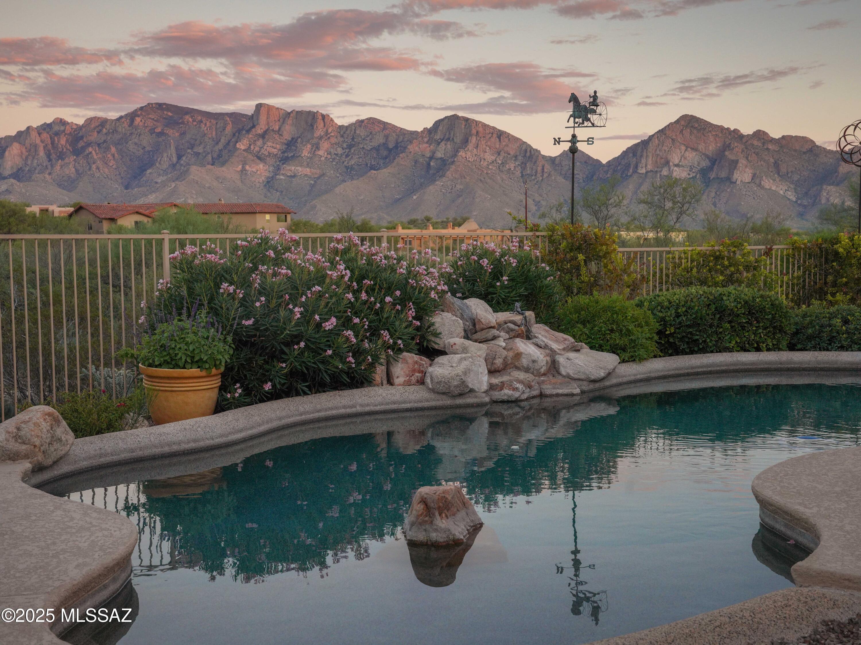 Where Luxury Meets Desert Serenity, you'll enjoy the panoramic Catalina Mountain and desert views the moment you enter this striking 3,391 SF residence, ideally situated on a private .69-acre east-facing lot in the heart of Oro Valley.  Designed for comfort, privacy, and style, the home features three bedrooms, four baths, a dedicated office with custom built desks & cabinets, and a 3-car garage. The foyer opens to a dramatic Great room with soaring 12' ceilings with artistic painted detail, polished concrete floors, and walls of windows framing breathtaking Catalina Mountain views. The well-appointed kitchen offers maple cabinetry, granite countertops, a spacious island with sink and seating, all appliances, walk-in pantry, and breakfast nook.  con't The Formal Dining Room glows beneath a statement chandelier, creating the perfect setting for both intimate dinners and festive gatherings.

The split floor plan ensures privacy. The north wing leads you to the tranquil primary suite with direct patio access and a spa-style bath featuring a walk-in shower, dual sinks, and a large walk-in closet.  The south wing features a spacious 400+ SF guest suite with a sitting area, a second guest bedroom, and a separate bath with pool access.

Step outside to a resort-style backyard with a sparkling pool, waterfall, shaded ramada, multiple patios, and vibrant desert landscaping all designed to showcase the sweeping Catalina vistas.  

Additional highlights include a TEP Guarantee solar system for energy efficiency; freshly painted exterior (Sept. 2025); power sun screen in the Great room; central vacuum; cobblestone paver driveway & much more.