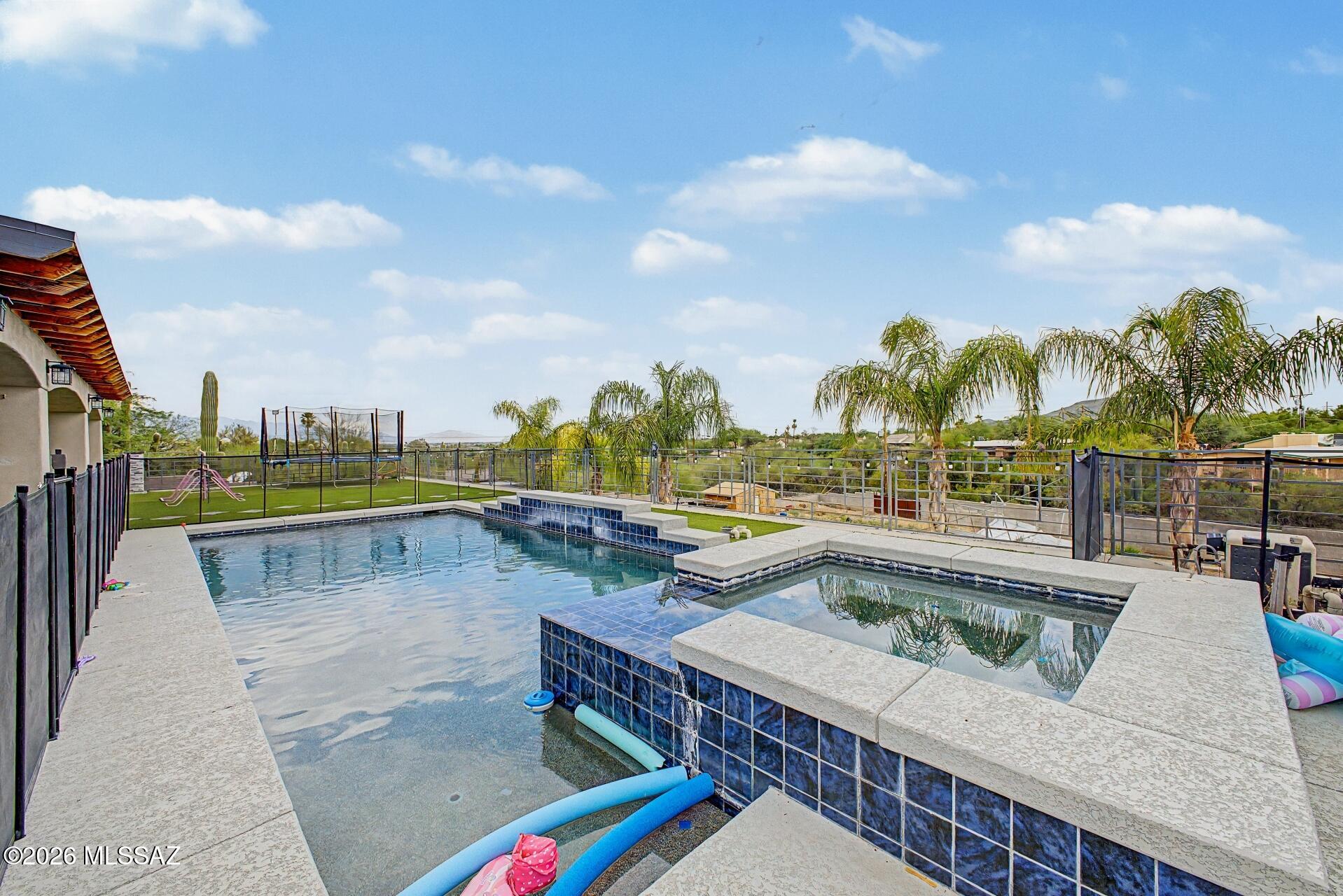 Fabulous home with pool and stunning views! Huge paver driveway leading to the 2-car garage, surrounded by attractive landscaping. Inside, the generous living spaces are ready to welcome you and your loved ones, featuring wood-look floors, contemporary lighting, a fireplace to ensure cozy winter evenings, arched passageways, and neutral tones promoting a modern feel throughout. The kitchen is a chef's dream, offering abundant cabinetry with crown molding finishes, tile backsplash, elegant granite counters, built-in appliances, and an island, perfect for meal prep and midnight snacks. The primary suite promises a good night's rest, offering a practical walk-in closet for easy organization, a bathroom with double vessel sinks, and direct outdoor access for convenience. The backyard oasis includes an expansive covered patio ideal for entertaining guests or relaxing with your favorite drink, artificial grass, a built-in BBQ, a paver seating area with a fire pit, perfect for nights under the stars, a relaxing spa, and a refreshing pool to enjoy sunny days! This remarkable home is THE ONE! Don't miss it!