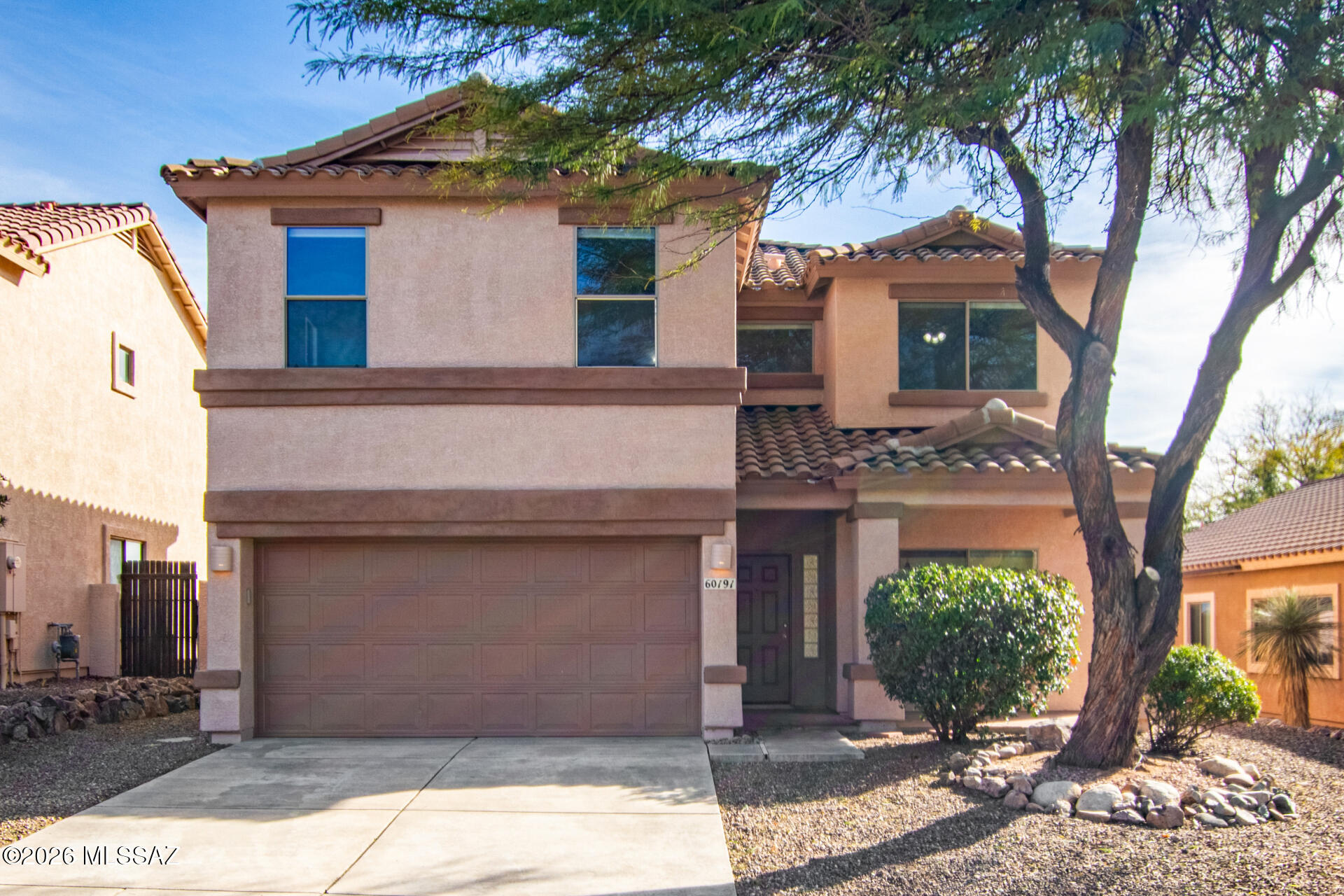 Located on a peaceful cul-de-sac in Catalina, this two-story home offers suburban comfort without the city hustle, paired with panoramic mountain views. Enter into a flexible living and dining area suited for a sitting room, home office, or reimagined dining space. An arched opening connects to the kitchen and family room, creating a true great room layout for everyday living. Tile flooring runs throughout the main level, with wood-look vinyl plank flooring upstairs. The home includes 4 bedrooms, an upstairs loft ideal for TV or game space, and 2.5 baths, including a convenient main-level powder room. The spacious primary suite features an ensuite bath and walk-in closet. Enjoy a large paver backyard with  mountain views and no direct rear neighbors-- an ideal backdrop for daily living.
