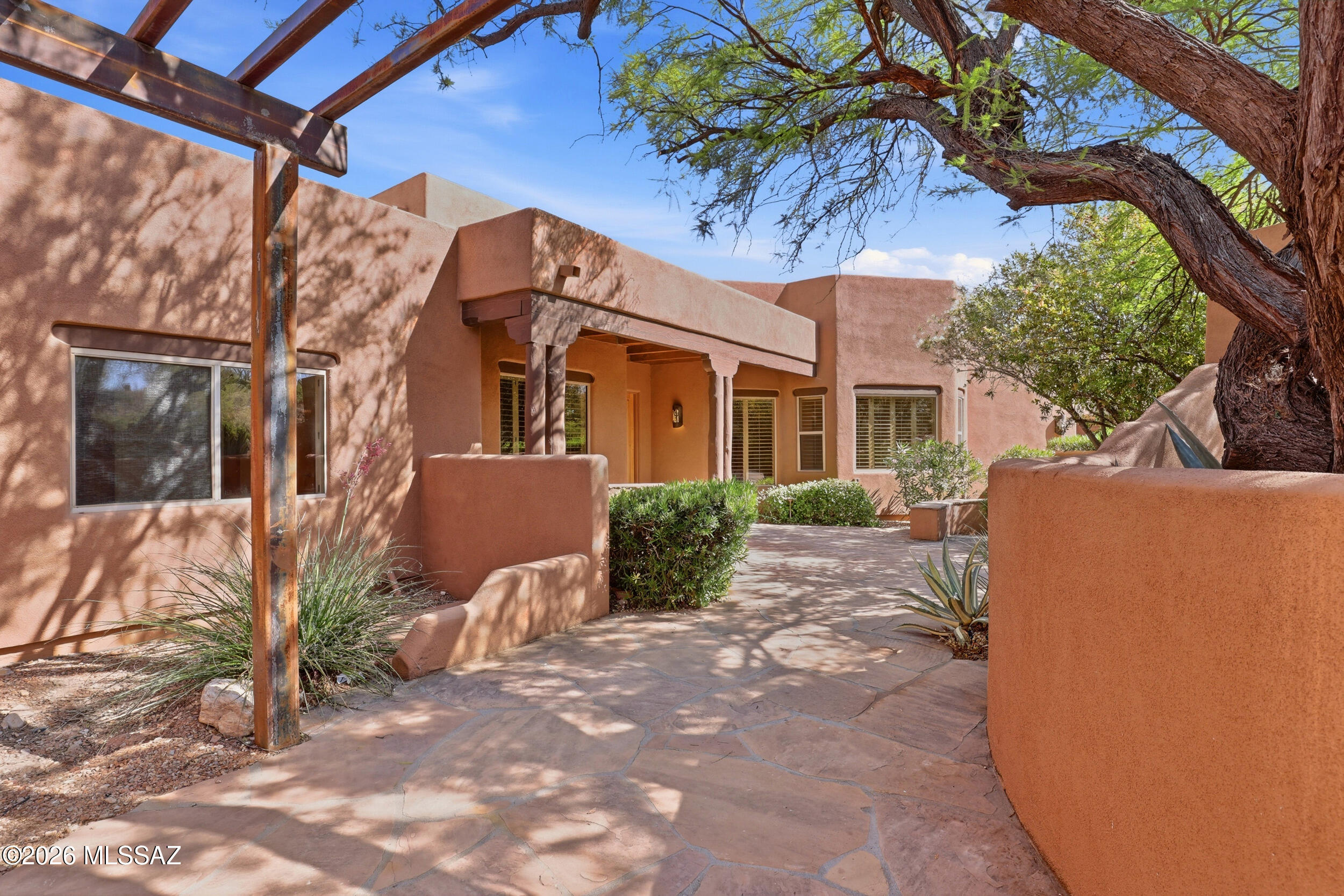 A rare opportunity to reimagine a distinctive Santa Fe-style desert retreat set on 1.18 acres in Oro Valley's idyllic Coyote Ridge neighborhood. Property offers sweeping mountain views, exceptional privacy, and mature desert landscaping. Two attached guest casitas with private entrances open to a charming front courtyard, while the main residence features a split floor plan for livability. Beamed ceilings and rough-hewn columns add character to the Great Room, which opens to the resort-style patio, pool, and spa. The updated kitchen features granite countertops, stainless appliances, and casual dining. Primary suite offers private pool access, an oversized walk-in closet, sauna and bonus rm for a study or fitness room. An exceptional opportunity to create your own refined desert sanctuary.