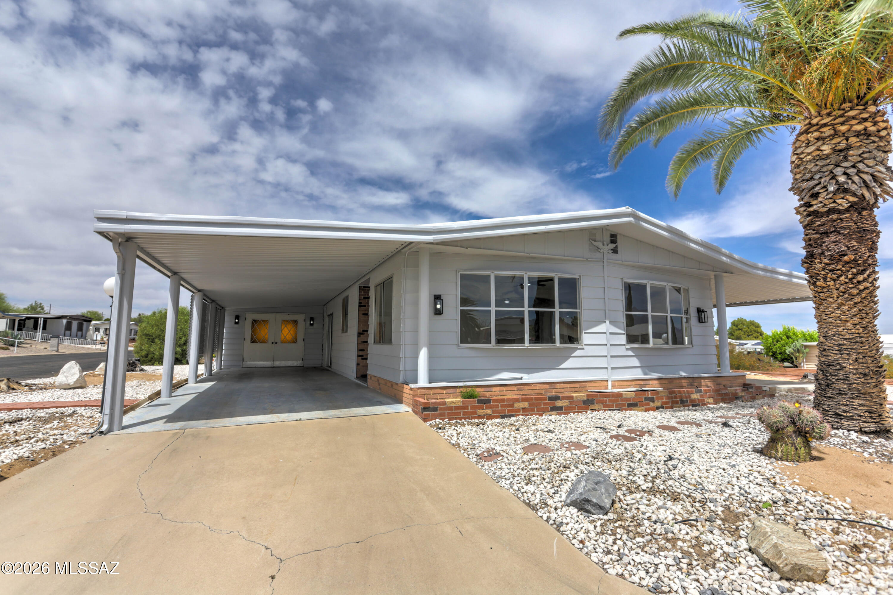 Experience the ultimate Green Valley retreat in this beautifully remodeled 3-bedroom, 2-bathroom home on a prime corner lot, where you own the lot (no space rent)!! 
The extensive renovation features fresh interior & exterior paint, designer lighting, stylish new flooring & carpet throughout, both bathrooms have been reimagined with new layouts and contemporary fixtures.
Enjoy a refreshed kitchen, dining area & ample storage, relax in the Arizona room featuring a cozy wood burning stove  with gorgeous views of the Santa Rita Mountains, or tinker in the large workshop that is the envy of any hobbyist. 
Take advantage of low HOA fees and a private recreation center with a heated saltwater pool, gym & more...