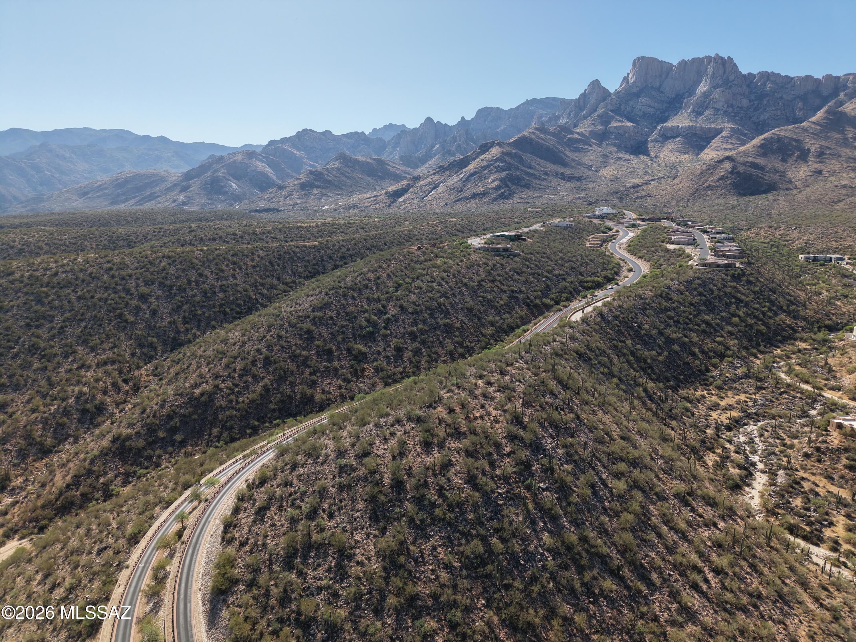 Perched high above the desert floor in a prestigious guard-gated community in Oro Valley, this exceptional hilltop vacant lot offers one of the rarest opportunities in the region--true 360-degree panoramic views stretching across the Sonoran Desert.  Set on an elevated homesite, the property provides a dramatic and commanding vantage point, ideal for a custom-designed estate that embraces both privacy and grandeur. The unique topography allows for architectural creativity, from expansive glass walls capturing endless horizons to resort-style outdoor living spaces perfectly positioned to take in sunrise-to-sunset views. A truly irreplaceable homesite, this lot is perfect for those seeking to design a legacy property that maximizes elevation, privacy, and unmatched panoramic scenery.