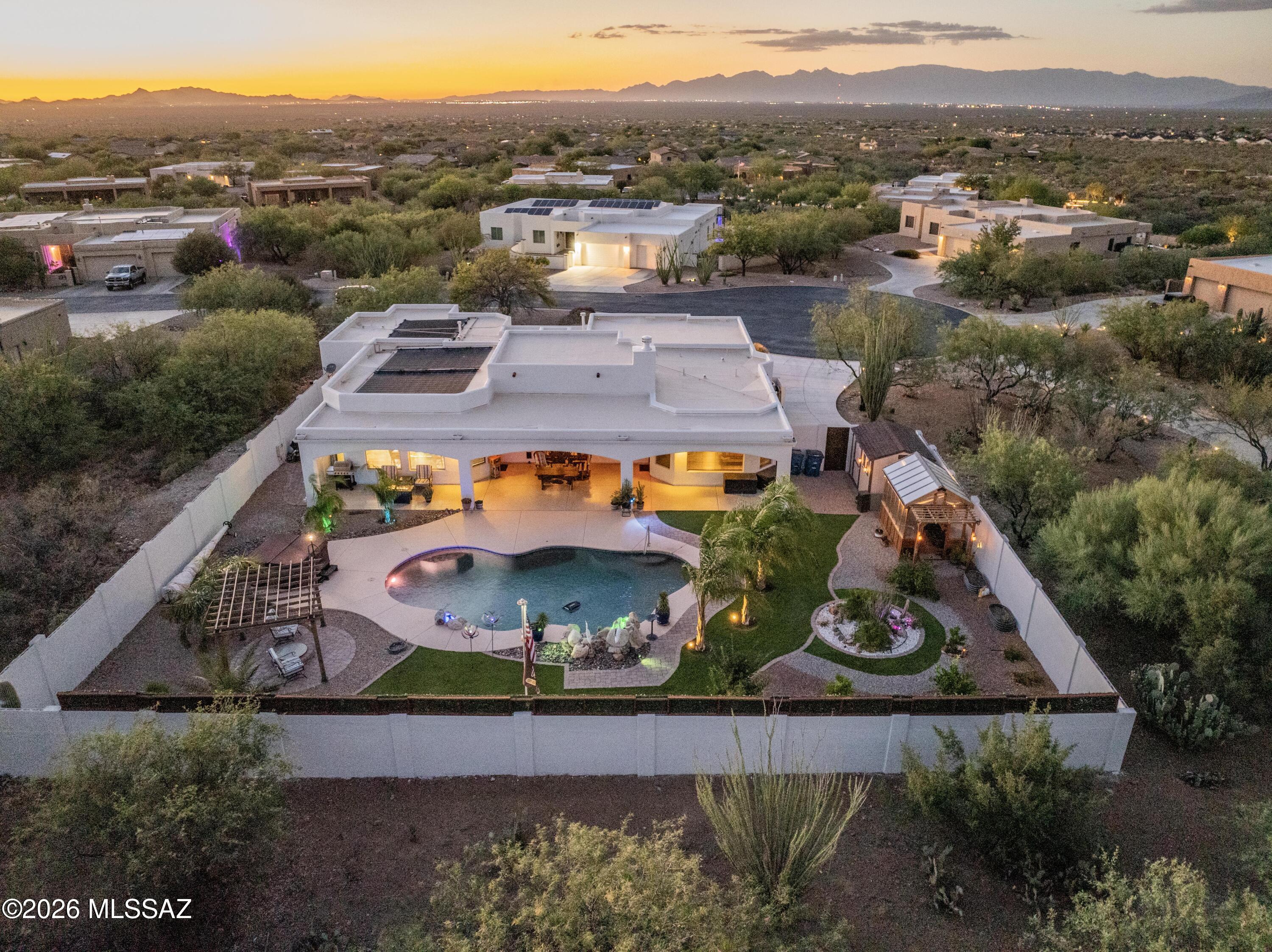 Luxury Living Meets Unforgettable Desert Beauty in Gated Sycamore Canyon. This is
the one buyers have been waiting for. Nestled on a private premium cul-de-sac lot spanning nearly an acre this exceptional semi-custom Sombra home captures breathtaking panoramic views of the Santa Rita Mountains and surrounding Tucson mountain ranges from nearly every room. Located within the highly acclaimed Vail School District, this residence offers the perfect blend of luxury, privacy, and Arizona lifestyle. Beautifully refreshed with new interior and exterior paint, this move-in-ready 4-bedroom, 3-bath home with a dedicated den/office showcases an expansive split-bedroom floor plan designed for both everyday comfort and effortless entertainment. The inviting courtyard entry welcomes you into a stunning great room featuring soaring ceilings, a charming beehive fireplace, surround sound pre-wire, and walls of windows that frame the spectacular mountain vistas. At the heart of the home, the gourmet chef's kitchen is designed to impress, featuring miles of granite countertops, custom cabinetry, stainless steel appliances, a gas cooktop, a walk-in pantry, and an oversized wraparound
breakfast bar perfect for gathering with family and friends. The spacious dining area and great room seamlessly flow to the outdoor living spaces through oversized sliding doors.
The luxurious primary retreat is a private sanctuary, offering stunning views, a spa-
inspired bath with soaking tub, walk-in shower, dual vanities, and a generous walk-in closet. The thoughtfully designed guest wing provides exceptional privacy with spacious secondary bedrooms and beautifully appointed bathrooms. Let's move outside and
experience your own desert resort. The extended full-width covered patio overlooks a sparkling PebbleTec pool with a waterfall, a relaxing spa, a lush turf area, and endless mountain views. You'll enjoy unmatched privacy, spectacular sunsets, and star-filled Arizona nights. A greenhouse and additional storage shed provide space for gardening, hobbies, and extra storage. Additional features include a 3-car garage with epoxy
flooring, zoned HVAC, ceiling fans throughout, water softener loop, a skylight in the laundry room, a long double driveway, and abundant storage. Rarely does a property combine this level of craftsmanship, privacy, breathtaking scenery, and resort-style amenities. This Sycamore Canyon retreat delivers the luxury lifestyle you've been searching for.