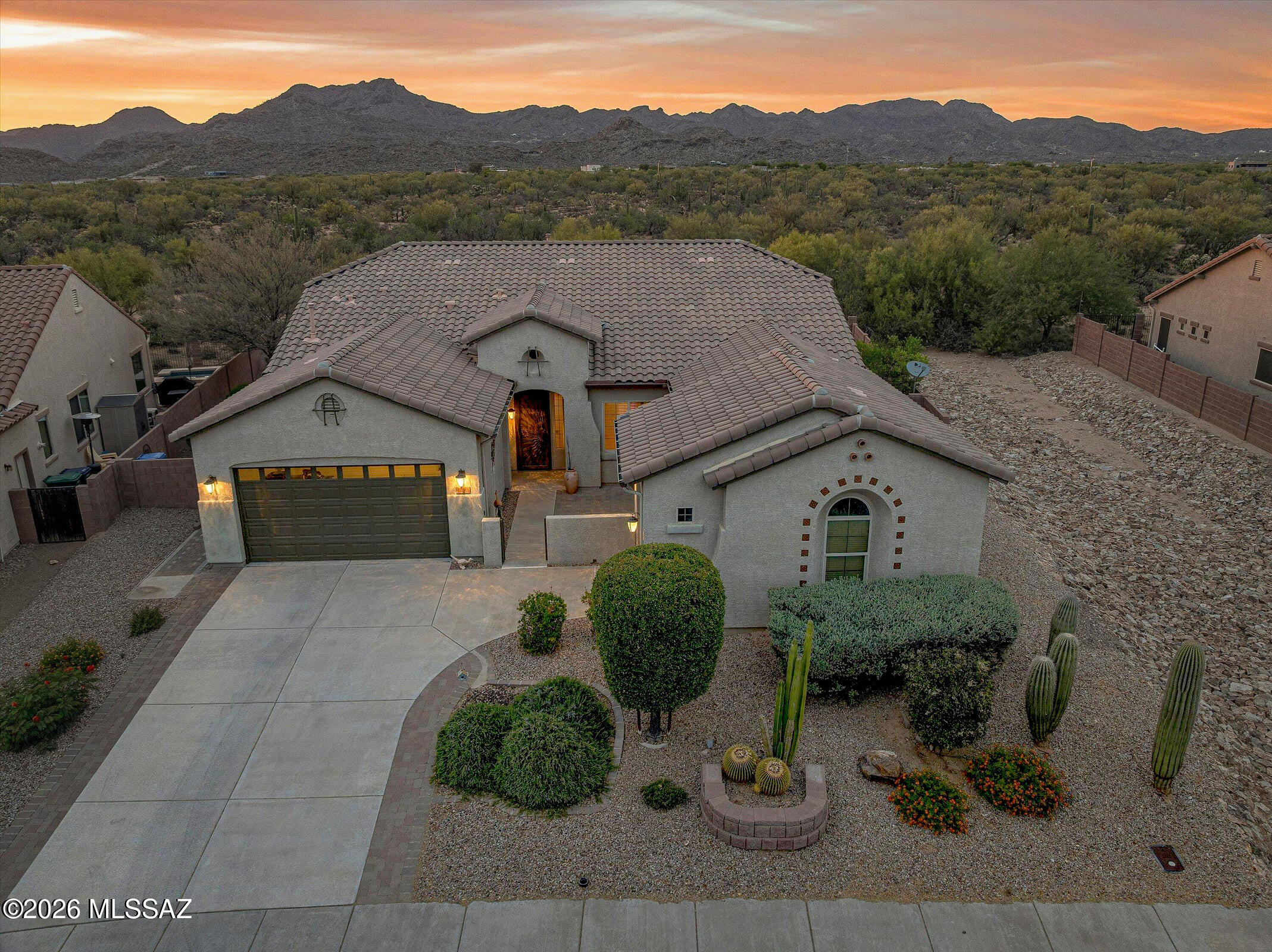 Located in the Gated Tangerine Crossing community, this well-maintained Maracay home sits on a premium lot backing to open space with no rear neighbors, offering privacy, mountain views, and a serene desert backdrop. Designed with 10-foot ceilings and a bright, open floor plan, the home features 3 bedrooms, 3 bathrooms, a 3-car garage, and flexible bonus spaces ideal for a den, office, fitness room, or media area. The kitchen is thoughtfully appointed with stainless steel appliances, double ovens, granite countertops, tile backsplash, crown-molding cabinetry, a pantry, and a large island with breakfast bar seating. The main living area offers tile flooring, built-in surround sound, a pellet-stove fireplace, and multi-slide glass doors that create a seamless connection to the covered patio. The primary suite includes private backyard access, a walk-in closet, and an ensuite bath with a soaking tub. Additional features include a gated courtyard entry, central vacuum system, whole house filtration plumbing, full irrigation, and an AC system replaced approximately two years ago. The backyard is designed for quiet enjoyment with covered patio space, built-in seating, a separate patio entrance, and open-space views that enhance the home's sense of privacy and setting.