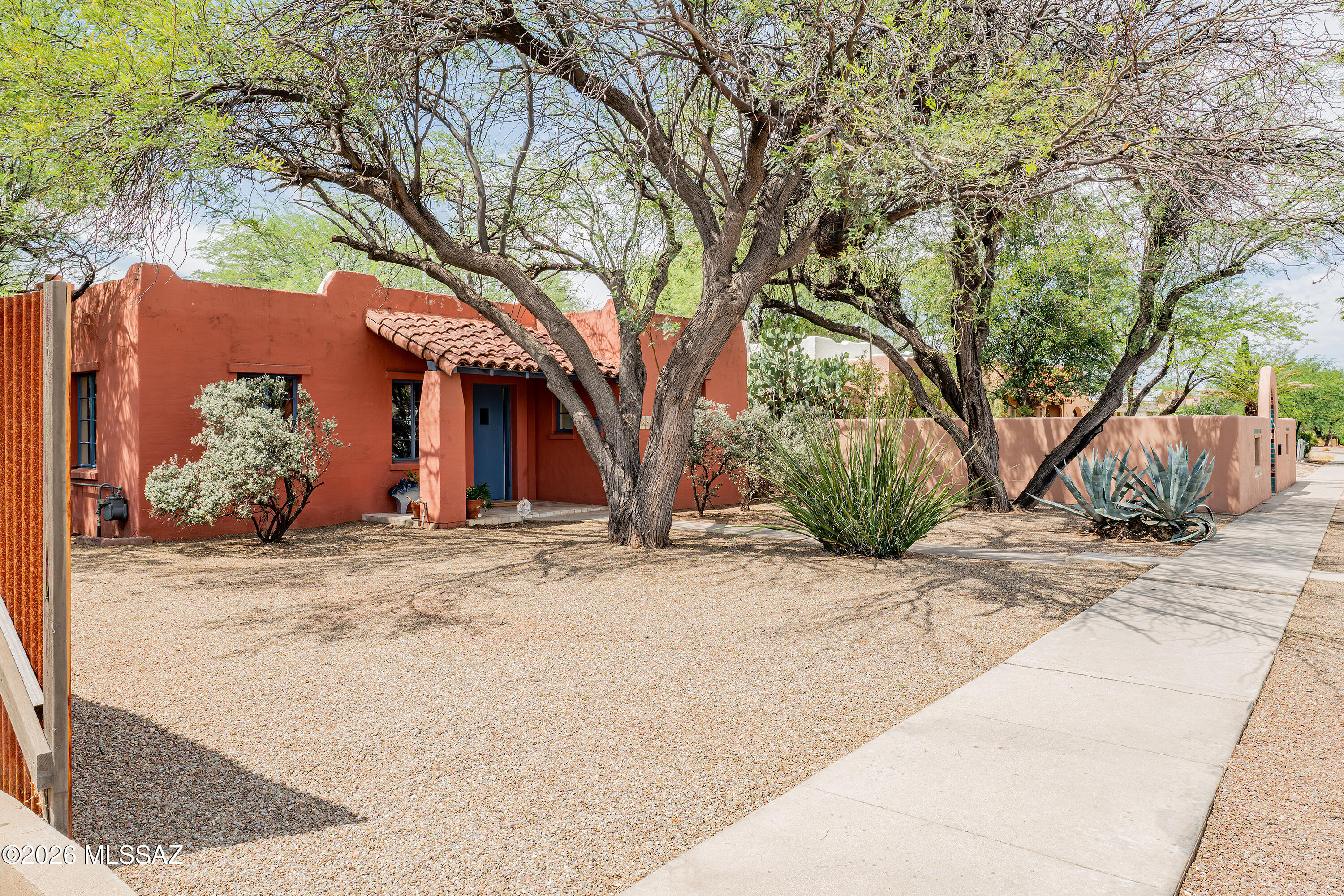Step into the historic charm of a 1936 Spanish Revival in the Sam Hughes neighborhood. Vintage details include original hardwood floors, tongue and groove beamed ceiling and classic fireplace. Also comes with a basement. 2026 improvements include new heating and A/C, water heater, roof and newly painted interior. In the large backyard, there's a 10x16 building used for storage, garage and separate large laundry laundry/storage room. Five water harvesting tanks to feed the gardens and trees. Three additional parking spaces off the south alley. Located on the National Historic Register and eligible for owner-occupant benefits. This is an estate sale and to be sold as-is.