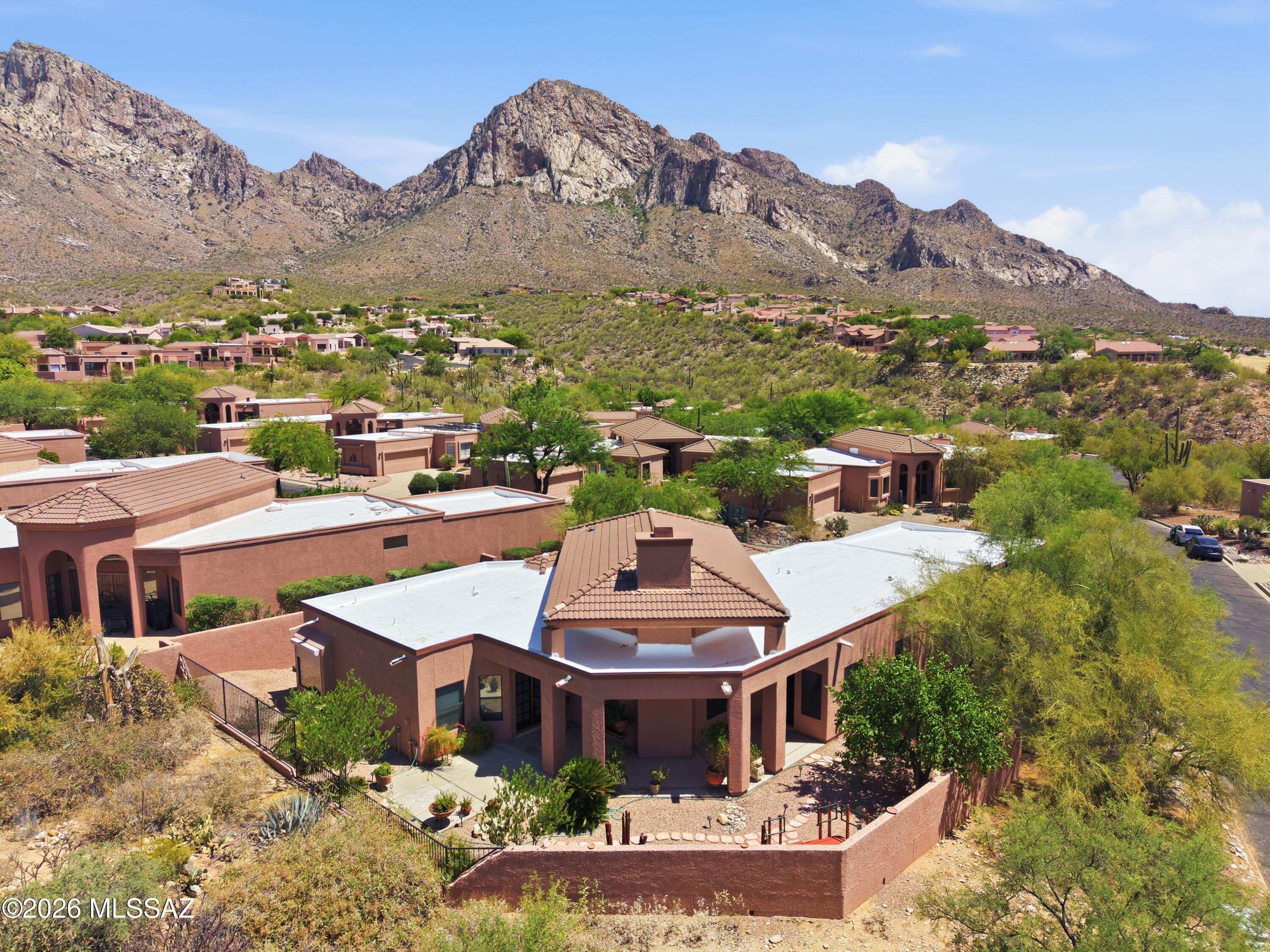 Welcome to your private mountain-side sanctuary in Oro Valley's highly coveted, guard-gated, Ram's Hill community of La Reserve! Perfectly situated on a premium corner lot that backs directly to a lush desert common area, this magnificent 3BD/2.5BA (2,349 sqft) residence offers the ultimate blend of sophisticated living, exceptional privacy, and sweeping, dramatic views of the Santa Catalina Mountains. Step inside to a light-filled interior that, offers an open floor plan that feels grand yet inviting. Designed with versatility in mind, the home features entirely separate Living, Dining, and Great Room spaces, giving you the ideal blueprint for formal holiday hosting or casual everyday relaxation. The expansive Great Room serves as the true anchor of the home, centered around a stunning custom stone fireplace perfect for those crisp desert evenings. The chef's kitchen is a culinary masterpiece, boasting a large center island with a glass cooktop, modern pendant lighting, stainless-steel appliances, and a breakfast bar layout. Enjoy your morning coffee in the adjacent, sun-drenched breakfast nook, where large picture windows frame gorgeous, unobstructed mountain views. The primary suite serves as a luxurious private retreat, complete with a massive walk-in closet and a spa-like ensuite bath featuring a deep garden tub and a separate custom tile shower. Two additional guest bedrooms ensure that family or working from home is an absolute breeze. Practicality meets luxury in spacious garage, which comes fully equipped with a professionally coated floor and extensive built-in storage cabinets. Outdoor living is pure magic, surrounded by native desert wildlife and serene natural buffers. Plus, residents enjoy access to a very private community pool and spa complete with dining ramadas and built-in grilling stations. Just minutes from the Oro Valley Marketplace and world-class hiking trailheads, this home offers a slice of high-desert paradise!