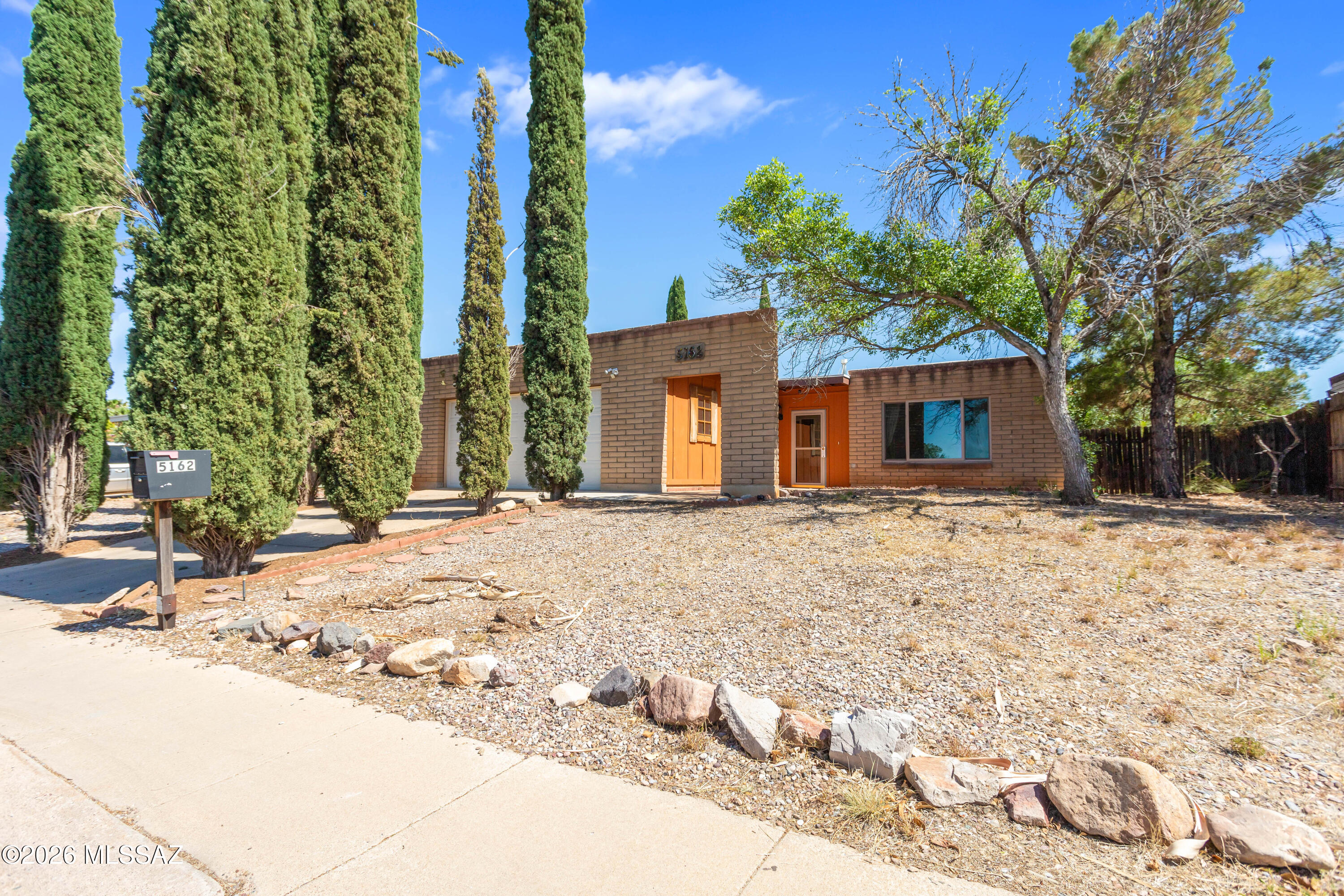 Experience the warmth and character of this inviting 3-bedroom, 2-bathroom Santa Fe-style home, featuring distinctive Southwestern charm throughout. A beautiful beehive fireplace serves as a stunning focal point, creating a cozy atmosphere in the spacious living areas. Designed for both everyday living and entertaining, the home offers separate family and living rooms, providing plenty of space to gather, relax, or host guests. The kitchen features a convenient breakfast bar and flows seamlessly into the living spaces, while the formal dining room is perfect for holiday meals and special occasions.  Outside, you'll find a fully fenced backyard offering privacy and room for pets, play, gardening, or outdoor entertaining. A recent roof replacement adds peace of mind.