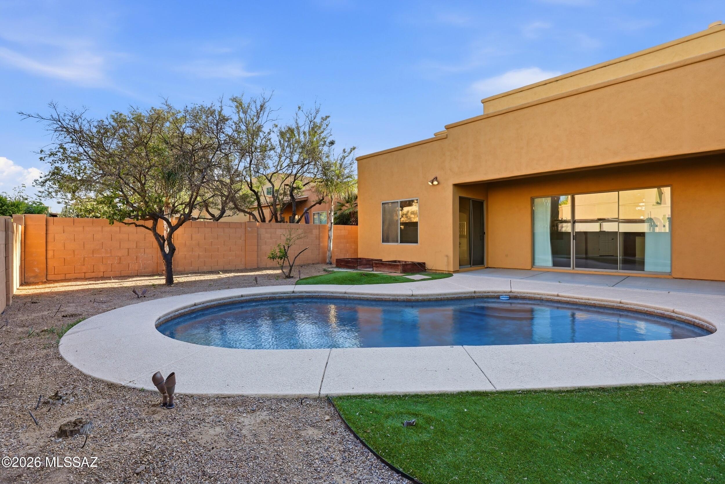 Located in the gated community of Red Adobe Pass, this beautiful Pepper Viner home offers 5 bedrooms, 3 full baths, a versatile loft, and a sparkling pool.

Inside, you'll find soaring vaulted ceilings, fresh interior paint, concrete flooring, a gas fireplace, and an open-concept layout designed for comfortable living and entertaining. The kitchen features stainless steel appliances, a breakfast bar, and a brand-new LG refrigerator.

The desirable floor plan includes a main-level primary suite with dual vanities, a soaking tub, walk-in closet, and direct backyard access. Two additional bedrooms and a full bath are located downstairs, while upstairs offers two more bedrooms, a full bath, and a flexible loft space. Enjoy Arizona living in the low-maintenance backyard featuring a covered patio and refreshing pool with a new pump and filter installed in 2025. Conveniently located in Northeast Tucson near Mount Lemmon, Sabino Canyon, Catalina Highway, Redington Pass, golf courses, shopping, dining, and endless outdoor recreation.