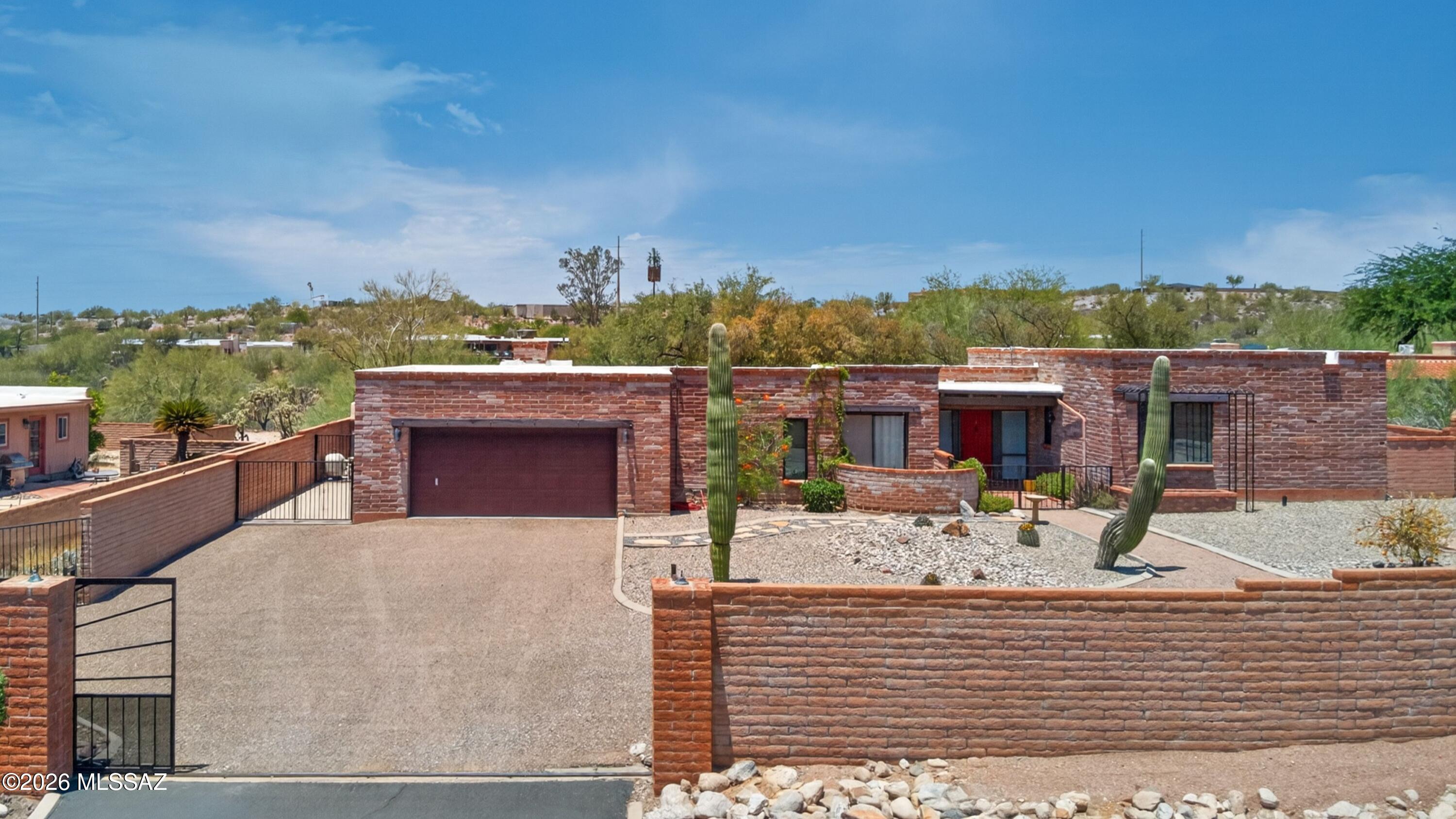 Range price seller will consider offers between 675,000-700,000. Quintessential Tucson burnt adobe southwestern style home in the Catalina Foothills. Four bedrooms and a den, three full bathroom split bedroom floor plan with open kitchen to family room and separate living and dining spaces. Saltillo tile and acid washed concrete floors throughout. Kitchen with stainless appliances, granite counter tops, glass tile backsplash, prep island, large closet pantry with barn door, cabinetry with several roll outs. Three updated bathrooms with granite vanity tops and tiled shower surrounds. Fully walled yard with gated entry. Mountain and city light views. Rear yard with pool with recent Pebble-Tec plaster, bee hive fireplace, covered patio and turf. Sliding glass doors from kitchen and family room to rear yard. Several skylights and solar tubes add natural light throughout the home.