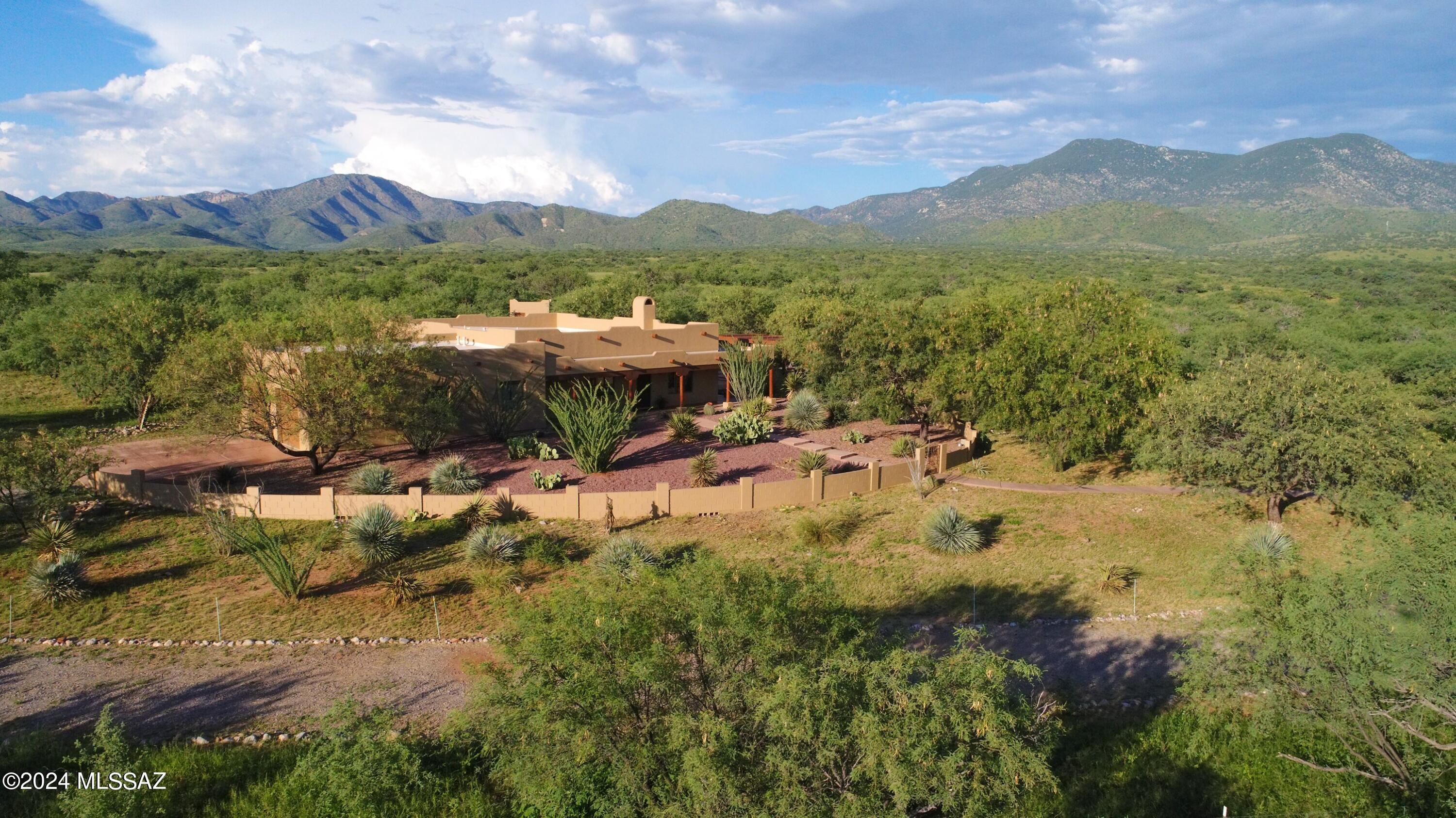 Vermilion Mountain Ranch is a must see property! It is offered TURNKEY with equipment and most furniture. This absolutely beautiful ranch includes 170 +/- acres of native grass lands with varied terrain & vegetation. It is a very picturesque setting with mesquites, huge oak trees, a magnificent riparian area & endless long views of mountains in every direction. The ranch is quiet & extremely private at the end of the road bordering thousands of acres of the Coronado National Forest & the Patagonia Mountains to the east. The owners have run a cow/calf operation here with Texas Longhorns & numerous horses. The ranch has a beautiful, impeccably maintained 3 bedroom, 3 bath home, 2 excellent wells, electric, 2 septic systems, corrals & a versatile 2,400 square foot barn/multi purpose building. Located 15 min from Home Depot, Walmart, Safeway, the Nogales International Airport and the Nogales Hospital. The ranch is being offered TURNKEY with a New Holland backhoe with only 800 hours and a Mahindra UTV with only 1,000 +/- miles and most all of the furniture stays. There is a brand new large RV shade port with 50 Amp electric service and water for you or your guests to park. One of the wells produces 70 degree water and both wells produce 30 GPM. There is a 500 gallon underground propane tank for the house and another 500 gallon tank for the generator at the barn. There are six livestock drinkers on the ranch and it is perimeter and cross fenced. Call for a showing now.