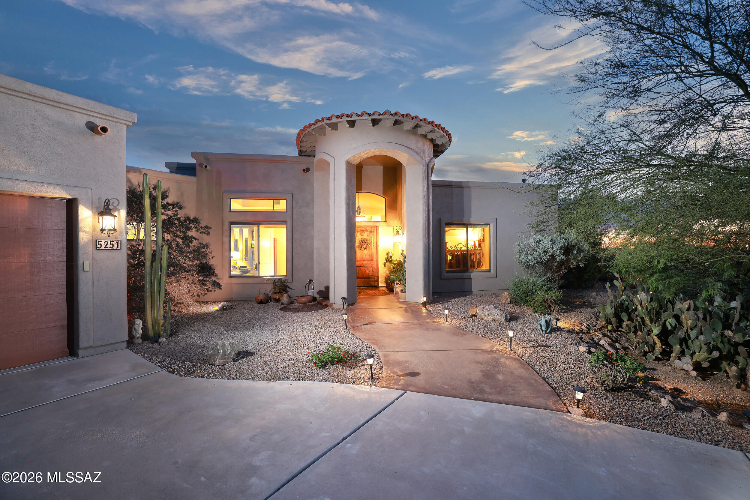 Very private & resort-like, this custom-built Northwest Tucson residence captures the essence of elegant desert living. Nestled on 2 acres surrounded by lush native flora & fruit trees, this exceptional property showcases breathtaking 360 views of the Catalina Pusch Ridge, Tortolita, & Tucson Mountains with sparkling city lights to the South & magnificent sunrises & sunsets painting the desert sky in every direction. The terraced wraparound patio, complete with remote-controlled electric shades & eyebrow extensions, provides an idyllic setting for a morning coffee or evening gatherings. Inside, the spacious 4-bedroom, 3-bath split-bedroom design features soaring 12-foot ceilings, walls of windows framing stunning mountain views, & a grand sense of space and light throughout. See Video The gourmet kitchen is a showpiece perfect for entertaining with an induction cooktop, Bertazzoni telescopic hood, granite countertops, and a generous breakfast bar. Elegant granite executive-height vanities and custom Knotty Alder cabinetry flow throughout, highlighted by a striking 8-foot solid entry door. The open great room centers around a warm wood-burning fireplace and newer French doors provide access to outdoor living spaces. A private guest suite with its own wing and entrance offers exceptional flexibility for multi-generational living or extended guests. Zoned for horses and complete with horse facilities. This Electric Energy Efficient home has an owned Solar System with net metering. Ideally located near The Loop multi-use path, Catalina State Park, The Gallery Golf Club, The Highlands Golf Club, and Tortolita Mountain Park, & Preserve, this property offers an unparalleled blend of serenity, privacy, and proximity to some of Tucson's most stunning recreational destinations. Only minutes from I-10, Shopping and Restaurants. (Be sure to view the video at the tab)