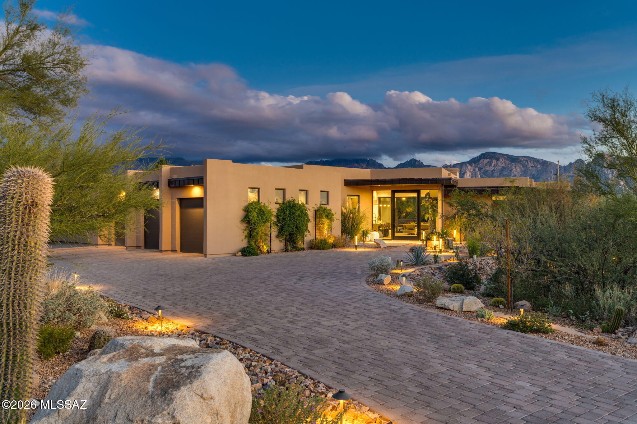 Step inside this stunning residence nestled within the exclusive Estates of Honeybee Ridge. Boasting sweeping views of the majestic Catalina Mountains, soaring ceilings and walls of glass. Every morning experience a gorgeous sunrise from your backyard oasis or from the perfectly appointed Primary Suite offering the same breathtaking views. Primary en-suite has an impressive walk-thru shower. 4 additional bedrooms and a flex room allowing plenty of space for family and guests. Open-concept interior is anchored by a chef's kitchen with impressive walk-thru pantry/espresso area. Kitchen features high-end appliances with 8 burner range, sleek countertops & custom cabinetry that flow seamlessly into dining and living spaces complimented by a modern fireplace.
