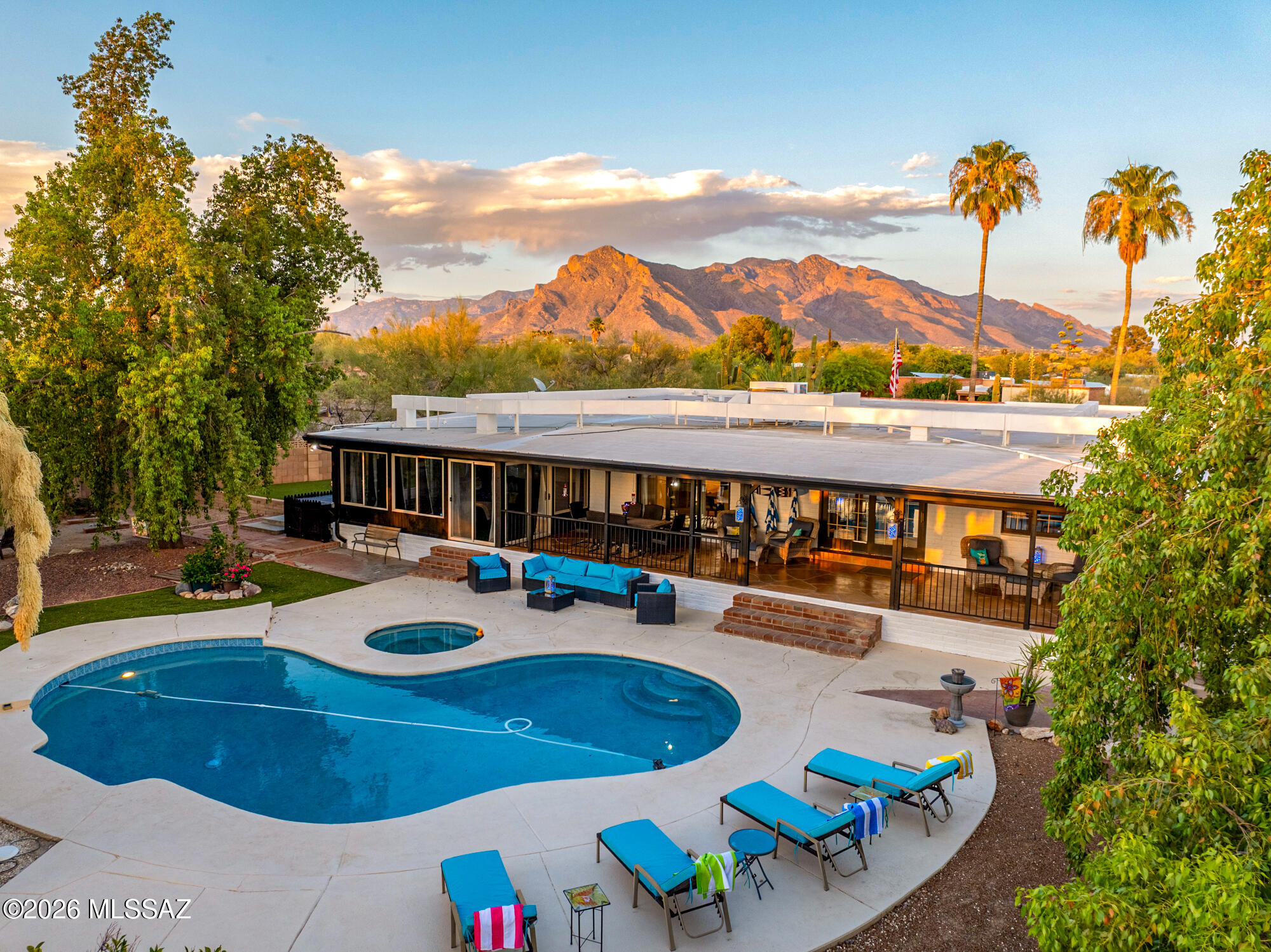 Welcome to this exceptional, fully reimagined Casas Adobes West home, where sophisticated style meets effortless desert living. The heart of the home is a showcase chef's kitchen, fully equipped with a massive quartz island, premium finishes featuring lighted cabinetry, a walk-in pantry, and professional-grade appliances including 3 ovens, ice maker and wine cooler. The flow is seamless into the dining space and generoulsly sized living room anchored by a cozy wood-burning fireplace PLUS a family room with walls of windows, bringing the outdoor view inside. Outside, you will find a beautifully landscaped private sanctuary featuring a sparkling pool, spa, covered patio, dining gazebo, and a fully equipped outdoor kitchen surrounded by mature shade trees, an entertainer's dream! The home's.. thoughtful layout offers distinct spaces for privacy and relaxation. The primary suite serves as a secluded sanctuary with its own private covered patio and courtyard. Visitors enjoy a VIP experience in the oversized guest room, which features an adjacent intimate library and sitting area, while a central architectural atrium elegantly connects the home's key living zones. Car enthusiasts, hobbyists, and fitness lovers will find paradise in the impressive four-car garage setup. This includes a standard attached garage plus a detached, oversized two-car garage tucked securely behind a private gate. Fully loaded with climate control, sleek coated floors, and French doors looking out to the yard, this flexible space is ideal for a high-end home gym, art studio, or luxury workshop. Complete with a massive laundry room, fresh exterior paint, and impeccable craftsmanship throughout, this gem of a home delivers the perfect blend of space, privacy and modern functionality.