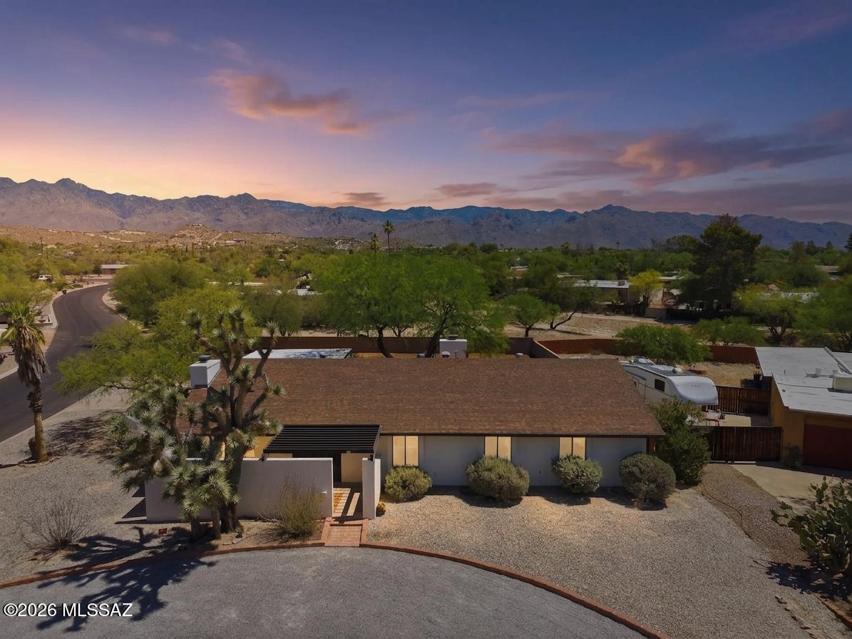 Unique opportunity for 4 bed/2.5 bath, 2,509 SqFt single story 1972 masonry stucco Mid-Century Modern Ranch on premium .43 acre CR2 corner lot with no HOA, space for RV/camper parking, daily Catalina mountain views located on whisper quiet street in desirable Sabino Vista neighborhood in North Tucson. Searching for character and charm? Yearning for nostalgia?? This vintage home is the next best thing to owning a time machine! Rare find priced below the $590K RVM property value report and below the Zillow ''Zestimate''. Owned by the same family since 1976 and offered for sale for the first time, this home showcases exceptional pride of ownership.
Featuring N/S orientation, architectural shingle roof, round driveway, 571 SqFt covered multiple car carport, expansive concrete driveway, on & off street parking, massive front mature joshua tree, masonry stucco walled side courtyard w/large mesquite shade tree, metal security doors and set of double wood doors. Step inside the foyer featuring original honey saltillo octagon flooring, textured natural seagrass wallpaper, step down into sunken living room with amazing natural light and wood burning fireplace, formal dining room, original light fixtures and hardware, original wood internal doors, wood siding, wired for alarm, copper plumbing, Trane gas HVAC (new 2023), digital thermostat, gas water heater (new 2023), intercom speaker system, laundry room with half/bath washer and dryer included. Wonderfully preserved vintage kitchen that captures the charm of a bygone era with yellow flowered-powered flooring, original avocado green 1973 Hotpoint dual oven, ample countertop space, original wood cabinets, peninsula counter with bar seating opens to spacious family room with stacked rock wood burning w/gas option fireplace, dining area with cool atomic telescoping light. Spacious bedrooms, guest bathroom w/executive height dual sink counter, fabric wallpaper, shower and tub. Large primary suite featuring slider to private backyard, ensuite full bathroom with dual sink counter, walk-in shower and exhaust fan.
Enjoy tranquil Tucson sunsets under extended covered 360 SqFt backyard patio, low maintenance backyard with omnipresent Catalina mountain views, gate access, storage shed with power, all surrounded by block privacy walls. The expansive lot provides ample space for a future swimming pool, outdoor entertaining areas, guest quarters, or simply enjoying the beauty of the Sonoran Desert.
Located walking distance to highly ranked Fruchthendler Elementary School, Tanque Verde Wash, the Chuck Huckelberry Loop ("The Loop") is a 131-mile, paved, shared-use path encircling the city and connecting with neighboring communities. It's designed for walking, biking, skating, and even horseback riding, offering a safe, car-free environment for recreation and commuting. Minutes away from acclaimed Sabino Canyon Park, Udall Park, shopping, groceries, pharmacy, banking and restaurants. 
This is your chance to own a piece of Tucson history while it is still available. They simply don't build houses like this anymore, call to make your appointment to view today!!