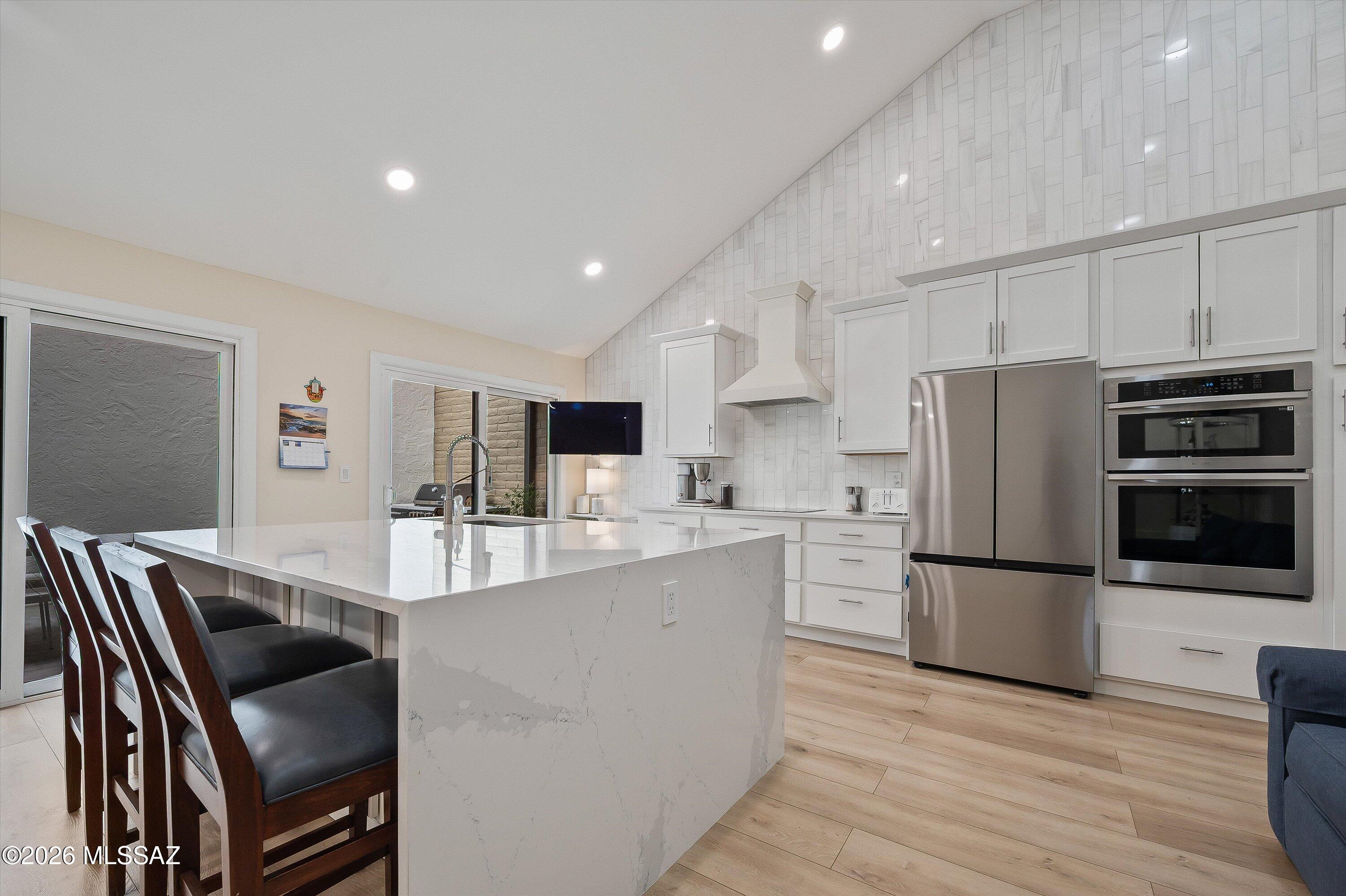 Welcome to this beautifully remodeled 2-bedroom, 2.5-bath townhome where thoughtful design, quality craftsmanship, and effortless living come together. Enter through a private courtyard into a bright, open floor plan with high ceilings, expansive windows, and abundant natural light. Every detail has been carefully considered to create a sleek, modern aesthetic while maximizing comfort and functionality. The inviting living room centers around a beautiful wood-burning fireplace. The spacious kitchen, dining, and living areas flow seamlessly, making entertaining a breeze. Both bedrooms offer generous closets with custom built-in organization systems, providing exceptional storage and everyday convenience. The luxurious primary suite features an oversized dual-head walk-in shower, creating a true spa-like retreat. Step outside to the spacious, low-maintenance backyard, ideal for relaxing, entertaining guests, or simply enjoying the stunning views of the Tucson desert. A two-car garage with additional storage provides plenty of room for vehicles, hobbies, and outdoor gear. Residents also enjoy access to community amenities, including a refreshing pool, relaxing spa, and clubhouse. This move-in-ready home offers the perfect combination of modern style, functional living, and exceptional desert surroundings.