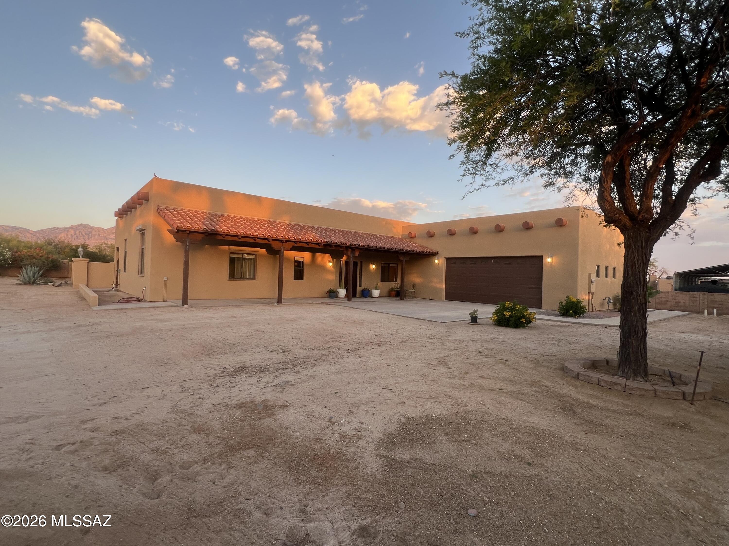 Tucked away in a cluster of custom homes sits this DESERT SANCTUARY w/ breathtaking Pusch Ridge views. A beautifully crafted 2002 custom 3bd/2ba home which is nestled on a full acre of flat, usable horse property. This single level gem perfectly blends Southwest charm and modern comfort with it's romantic Beehive fireplace, soaring wood beam ceilings, natural light that floods each room; highlighting the warmth of the scored concrete floors, and custom wood blinds throughout. Large, open kitchen with Kraftmaid Hickory cabinets, new stainless-steel appliances. Mature desert vegetation surrounds the property providing natural privacy while attracting local wildlife. Built in BBQ, 2.5 car garage, tons of storage, New interior/exterior paint. Turn-key absolutely spotlessly clean home Call Agent/Owner Heather Poyas 520-907-5711