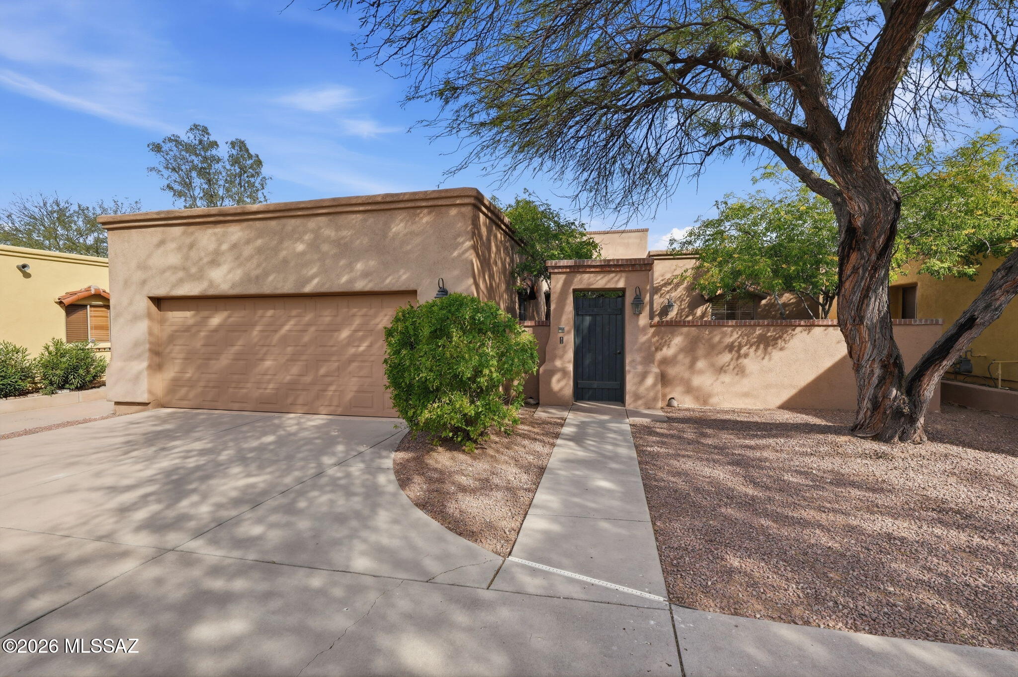 Set within a quiet gated enclave, this Santa Fe style 3 bed/ 2bath home offers warmth, privacy, and refined desert living. The great room features beamed ceilings, a gas fireplace, and skylights that bring in natural light. The kitchen includes granite tile counters, pantry storage, and black appliances. The split bedroom plan provides a peaceful primary suite with a double vanity, walk in shower and a walk-in closet. Enjoy low care landscaping, a covered patio, and an attached two car garage.. This well kept home blends comfort and style in the heart of central Tucson.