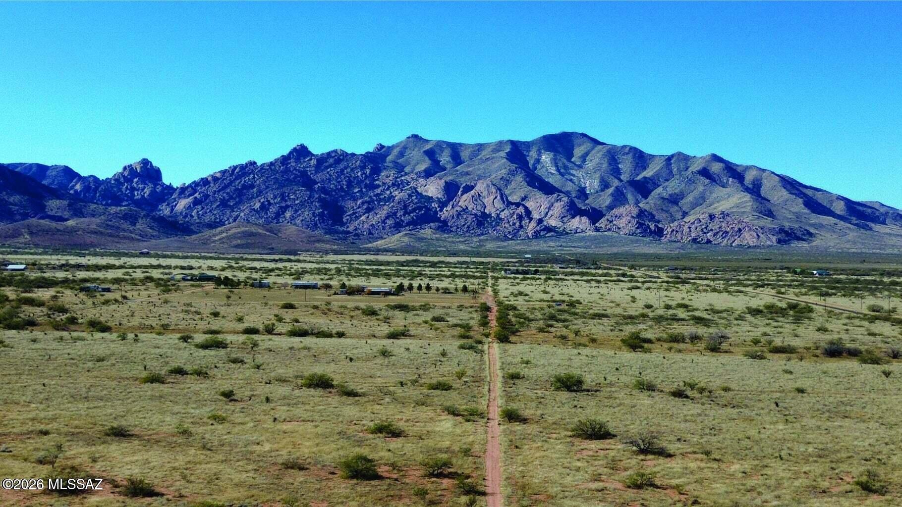 Great flat, buildable lot with easy road access! These three combined parcels offer over 2.5 acres of opportunity, showcasing stunning views in every direction. Take in the expansive Dragoon Mountains and surrounding farmland right from your property. No HOA! Located in a master-planned community with utilities nearby. Build your dream home or bring in a new manufactured home--your choice! Buyer to verify utilities. The zoning on this parcel is Cochise - SR-22. Cochise County, Arizona, the SR-22 (Single-Household Residential) zoning district requires a minimum parcel size of 22,000 square feet (approximately 0.5 acres). It permits low-density, single-family detached homes, but strictly prohibits mobile homes, manufactured homes, and recreational vehicles from being used as primary residences.Permitted Uses Primary Residences: Single-family detached dwellings.Accessory Uses: Guest houses, home occupations (with limitations on traffic, noise, and outdoor storage), and private garages/workshops.Other Uses: Religious institutions (churches), utility installations, and residential care homes. 

Yes, Cochise County allows you to live in an RV on an SR-22 zoned property while building a home, provided you obtain a Temporary Use Permit from the county.