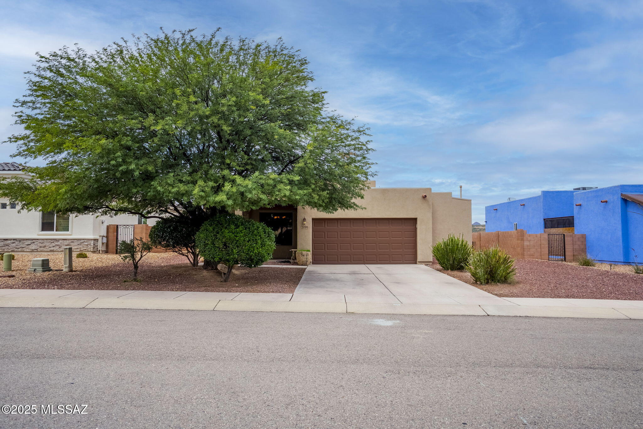 Welcome to this stunning Santa Fe-style residence in the highly desirable Bella Vista subdivision of Rio Rico. This immaculate 3-bedroom, 2.5-bath home offers a bright, open-concept floor plan that perfectly blends Southwestern charm with modern comfort. Step inside to a spacious living room featuring a cozy gas-burning fireplace, ideal for relaxing evenings. The dining area flows seamlessly into a fully equipped kitchen complete with a walk-in pantry, ample counter space, and perfect for cooking and entertaining. The primary suite provides a peaceful retreat with plenty of natural light, while the additional bedrooms offer flexibility for family, guests, or a home office. Outside, the property is fully walled for privacy, offering a blank canvas backyard ready for your personal touch, whether that's a garden, or outdoor living space. With no neighbors behind and mountain views, this home truly captures the essence of desert living. Located in a well-maintained community featuring a park, sidewalks, and a community pool, this home is just minutes from supermarkets, restaurants, schools, I-19, the post office, medical clinic, and gas station combining peaceful living with everyday convenience. Come take a look at 1096 Vista De Los Alamos, it's truly a beautiful home!