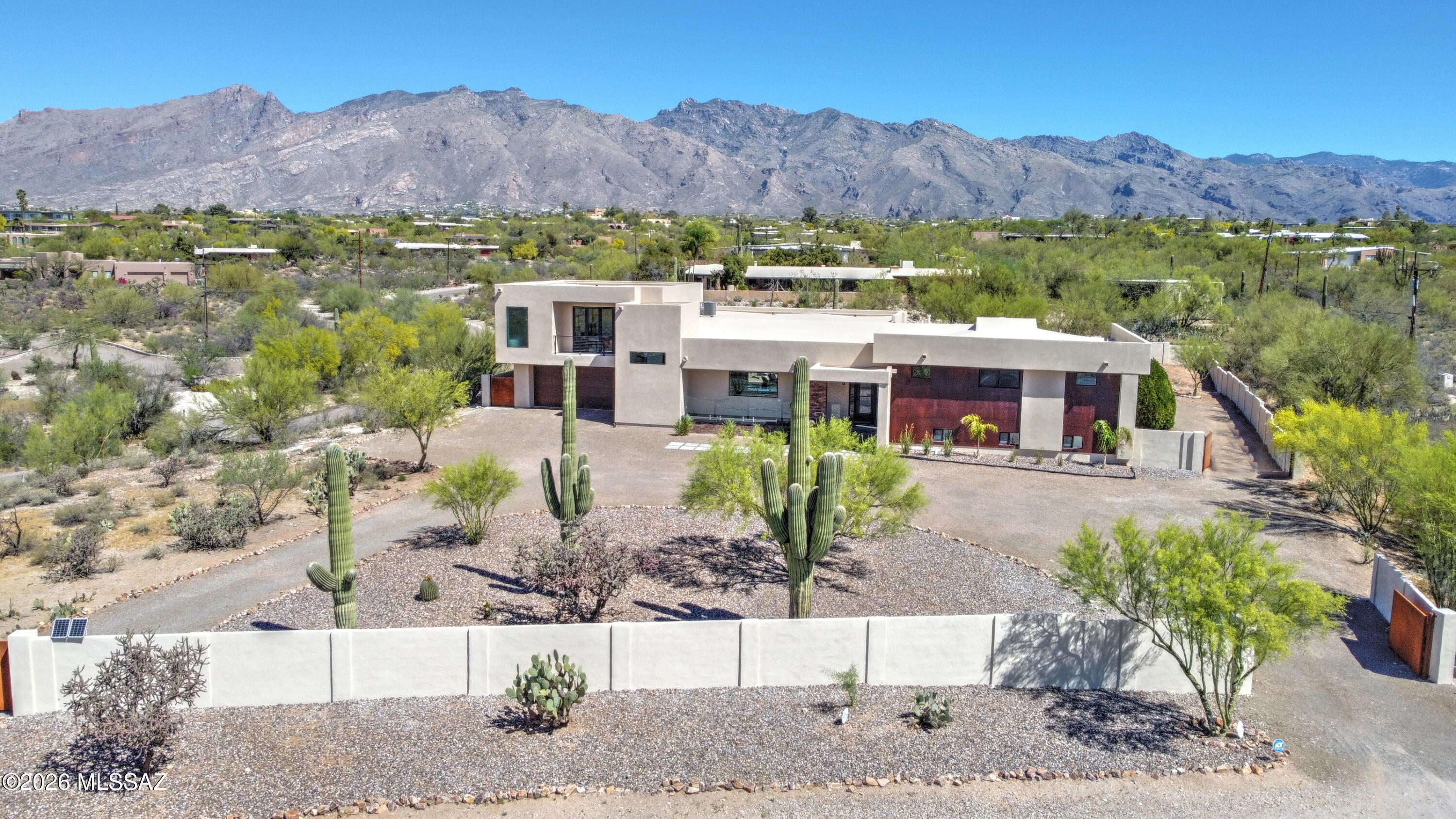 Agent/Owner Elevated desert living with panoramic city and mountain views in this beautifully updated home. This exceptional modern residence was thoughtfully designed by renowned architect Kevin B. Howard. Freshly painted inside and out, the interior features new luxury tile, dual-pane windows, an inviting foyer, formal dining, and a split-bedroom floor plan with walk-in closets and abundant storage. The kitchen showcases quartz countertops, new cabinetry, stainless steel appliances, a large island, and walk-in pantry. The private primary suite offers a fireplace, bath with marble finishes, dual vanities, soaking tub, walk-in shower, and private patio access. Enjoy a recreation/entertainment room in the basement Outdoor spaces include balconies, deck, covered patio, water feature, desert landscaping, fenced yard, circular drive, and 2-car garage with community RV parking.