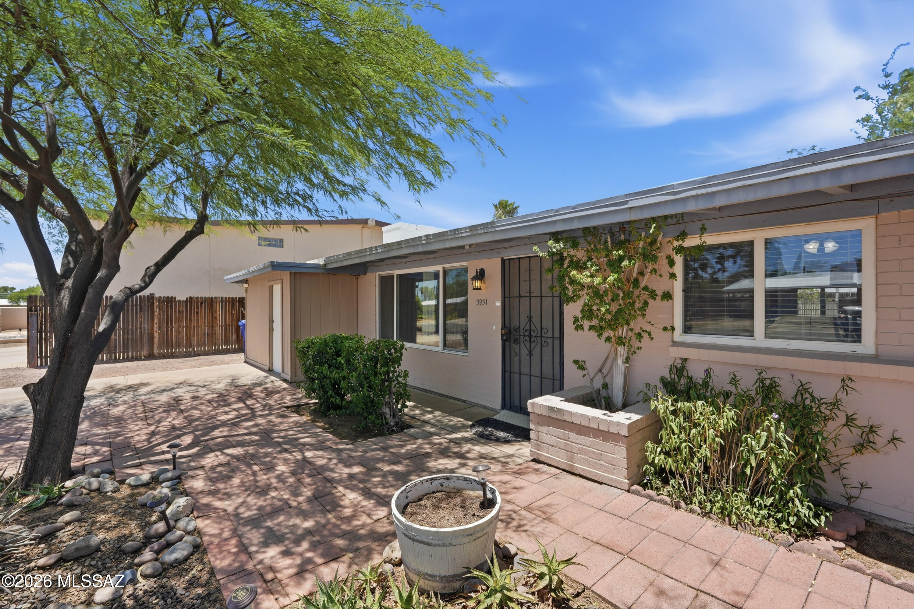 A rare opportunity, this thoughtfully adapted 1954 wheelchair accessible family home features an open floor plan, beamed ceilings, cozy brick fireplace, and tile floors. Expansive Northern windows fill the home with natural light. The kitchen features lowered counters, cooktop, oven and sink for ease of use. The spacious Primary Suite has widened doorways, a roll-in shower and jacuzzi bathtub. The workshop area provides potential for additional living space or extra storage. The paved landscaped backyard features an inviting fenced pool. Located within walking distance of Park Mall this wheelchair accessible home could also accommodate two people and a caregiver, making it a unique opportunity.