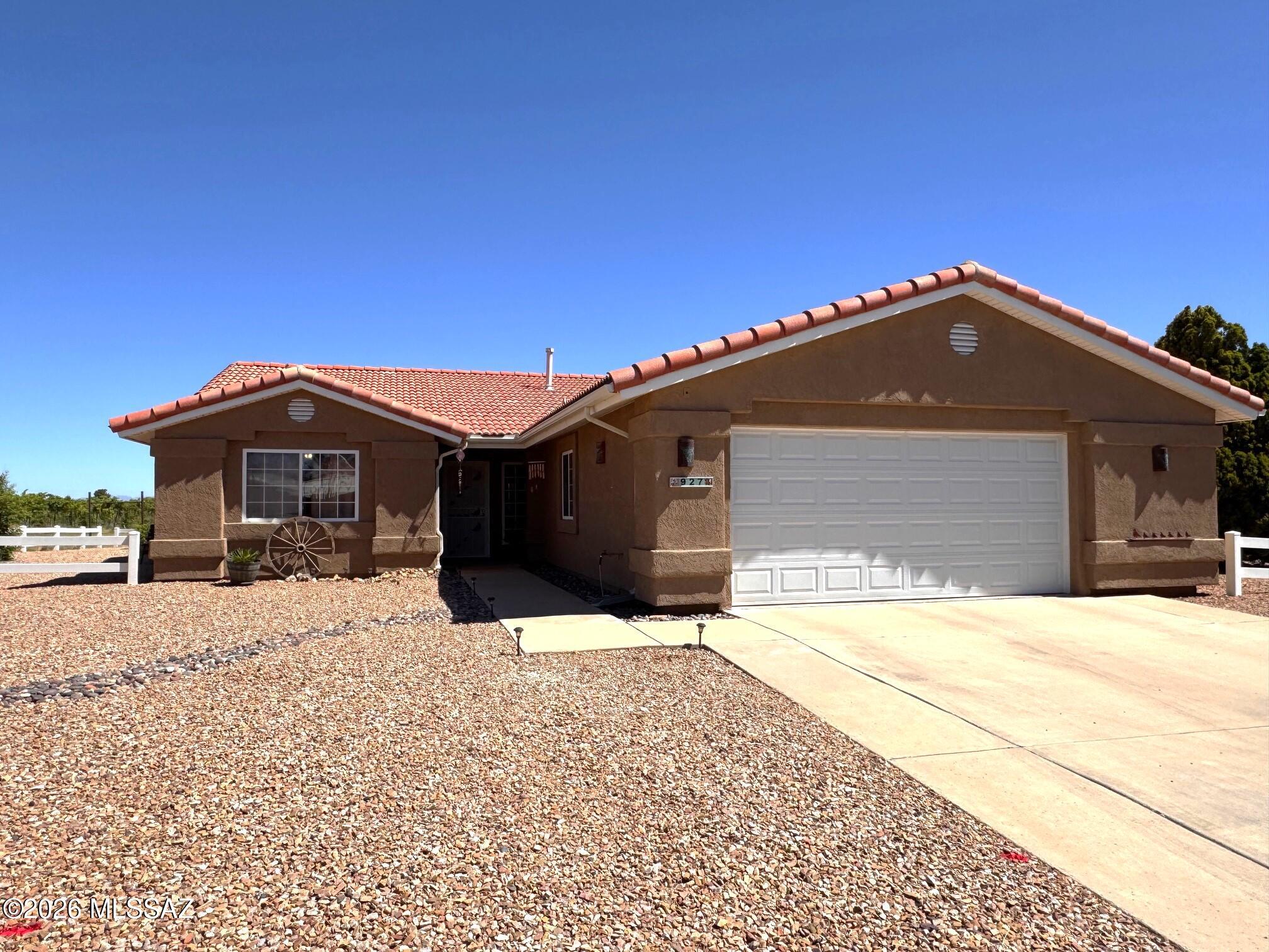 Beautifully maintained home siturated on a desirable corner lot overlooking a picturesque vineyard, with breathtaking views of the iconic Cochise Stronghold. Enjoy Arizona's stunning sunsets & peaceful surroundings from the spacious pergola-covered patio and large stained concrete entertaining area-perfect for outdoor gatherings, relaxing, or simply taking in the scenery.  The oversized garage is a standout feature, offering abundant built-in cabinetry along multiple walls for exceptional storage and organization, EV charging station plus a dedicated heating & cooling unit for year-round comfort. Numerous recent upgrades include a new garage door & washing machine (2025), new carpeting (2024), new stove, microwave, & refrigerator (2024), updated toilets, faucets, & fixtures. This move-in-ready home combines comfort, functionality, and spectacular views in one exceptional package.
