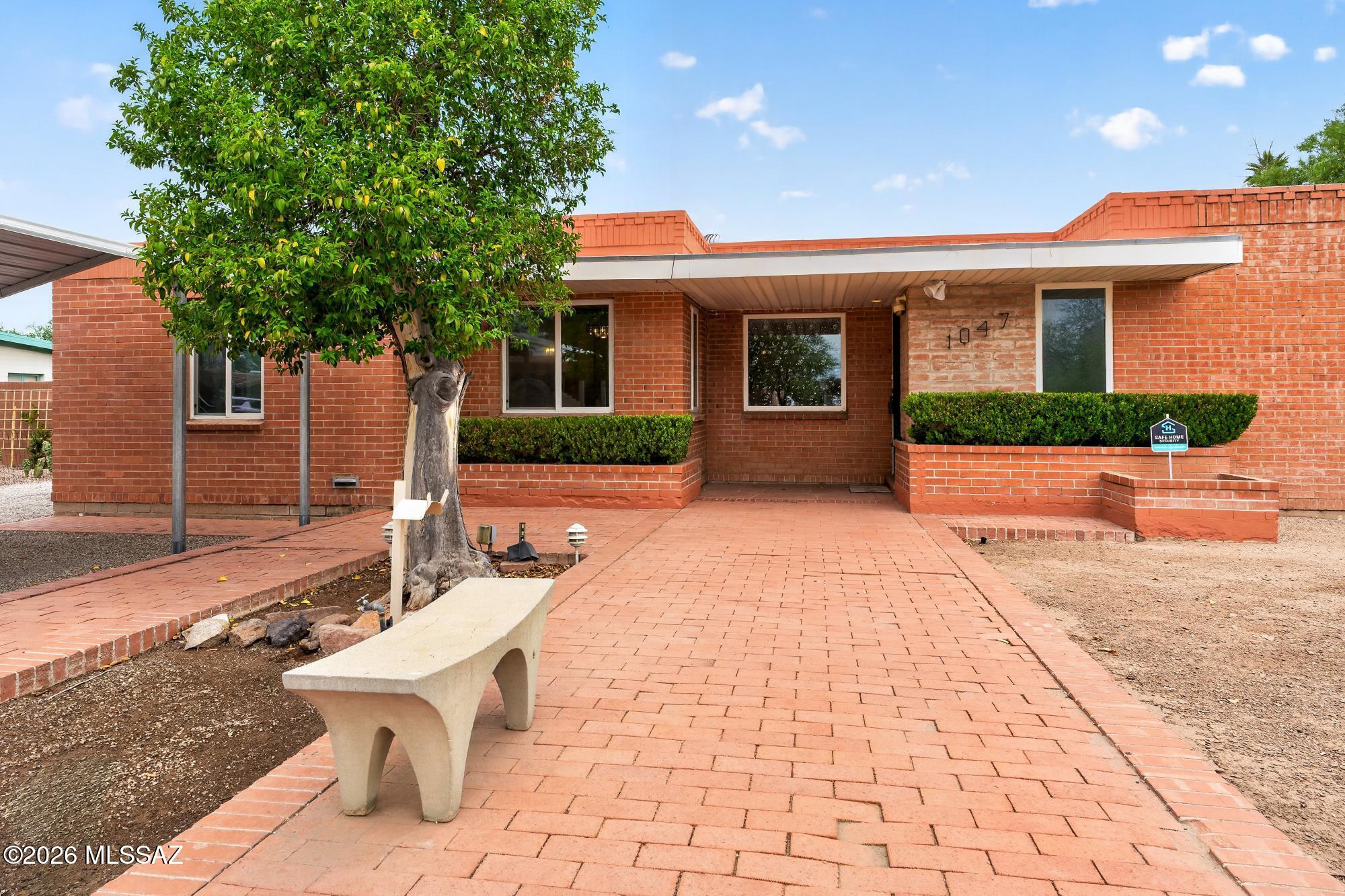 This double-brick 1950s ranch home has had many upgrades, including a full re-plumb in 2024 with a transferable 25-year warranty and dual-pane windows for improved energy efficiency. The roof was recently recoated and includes a 2-year warranty, providing added peace of mind. With major systems already addressed, the home offers a wonderful opportunity to add your own cosmetic updates and personal touches. Upon entry, the living room welcomes you with a fireplace that sets a warm and inviting tone. Designed with both entertaining and bedroom privacy in mind, the split 3-bedroom floor plan with an office offers versatility for work, guests, or hobbies. A spacious family room provides additional gathering space, while a light-filled atrium brightens three rooms. The dining room features a genuine flagstone floor, adding warmth and character.
Ideally located near the University of Arizona, the Mountain Avenue Bikeway, Cat Tran parking, as well as nearby shopping and dining, this home offers convenient access to some of Tucson's most popular amenities. Outdoor living is equally inviting. The family room opens to a covered patio featuring a custom red-brick fireplace, creating a perfect space for entertaining and year-round enjoyment. Just off the patio, the sparkling 20' x 40' pool maximizes Tucson's outdoor lifestyle. The front bedroom opens to its own private patio retreat, and two large backyard storage sheds provide additional convenience. With key systems upgraded, this home offers character, space, and the chance to create something truly special.