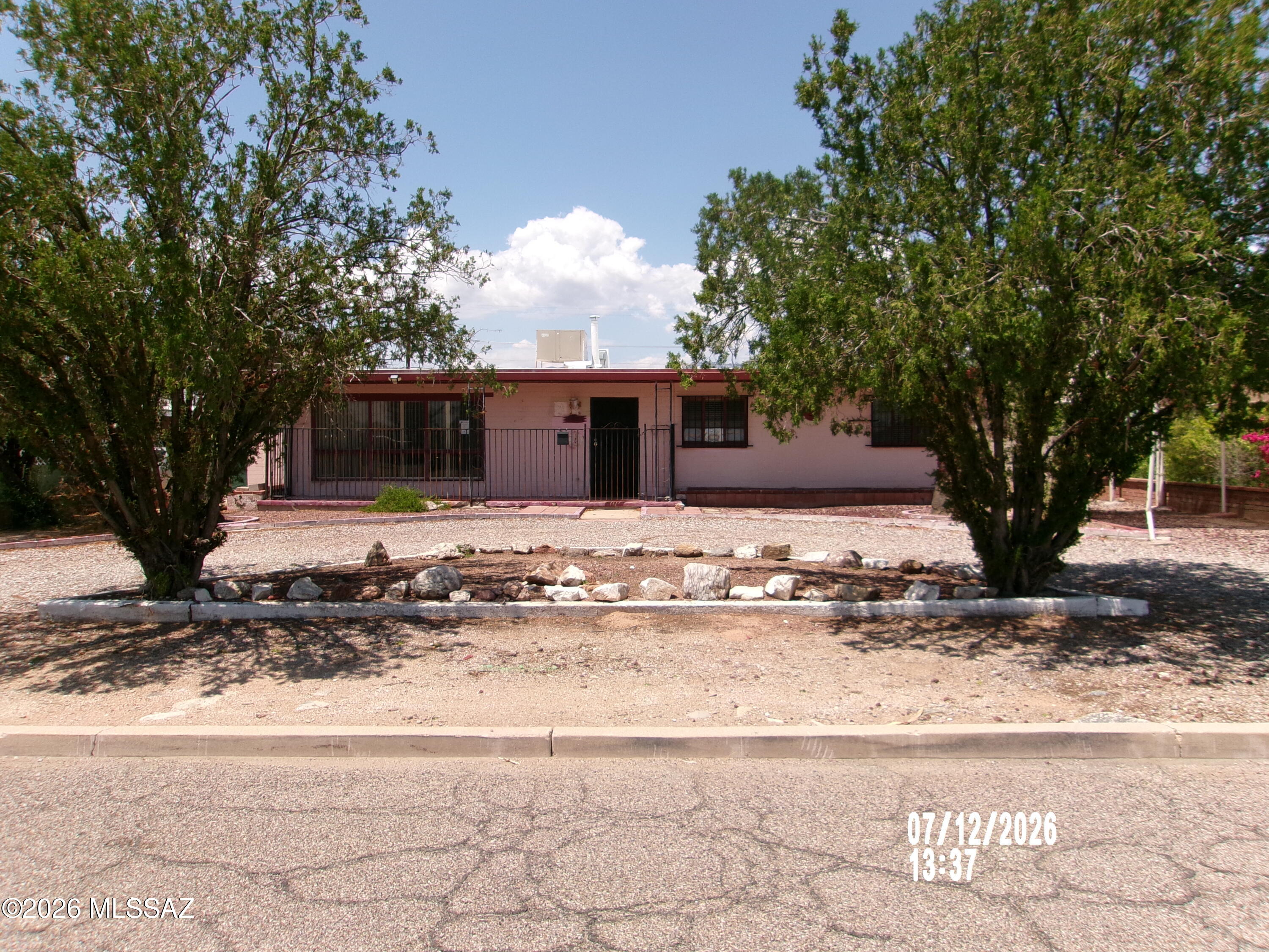 Visit this mid-century brick ranch charmer in central Tucson featuring a huge living room with a fireplace, a formal dining room,  two bedrooms plus a multi- purpose room for  easy set up for a third bedroom, den or home office.  Spacious back yard with outbuildings for a workshop or storage.  All this plus a circular front driveway!   Make this your home and add your touches to it!
