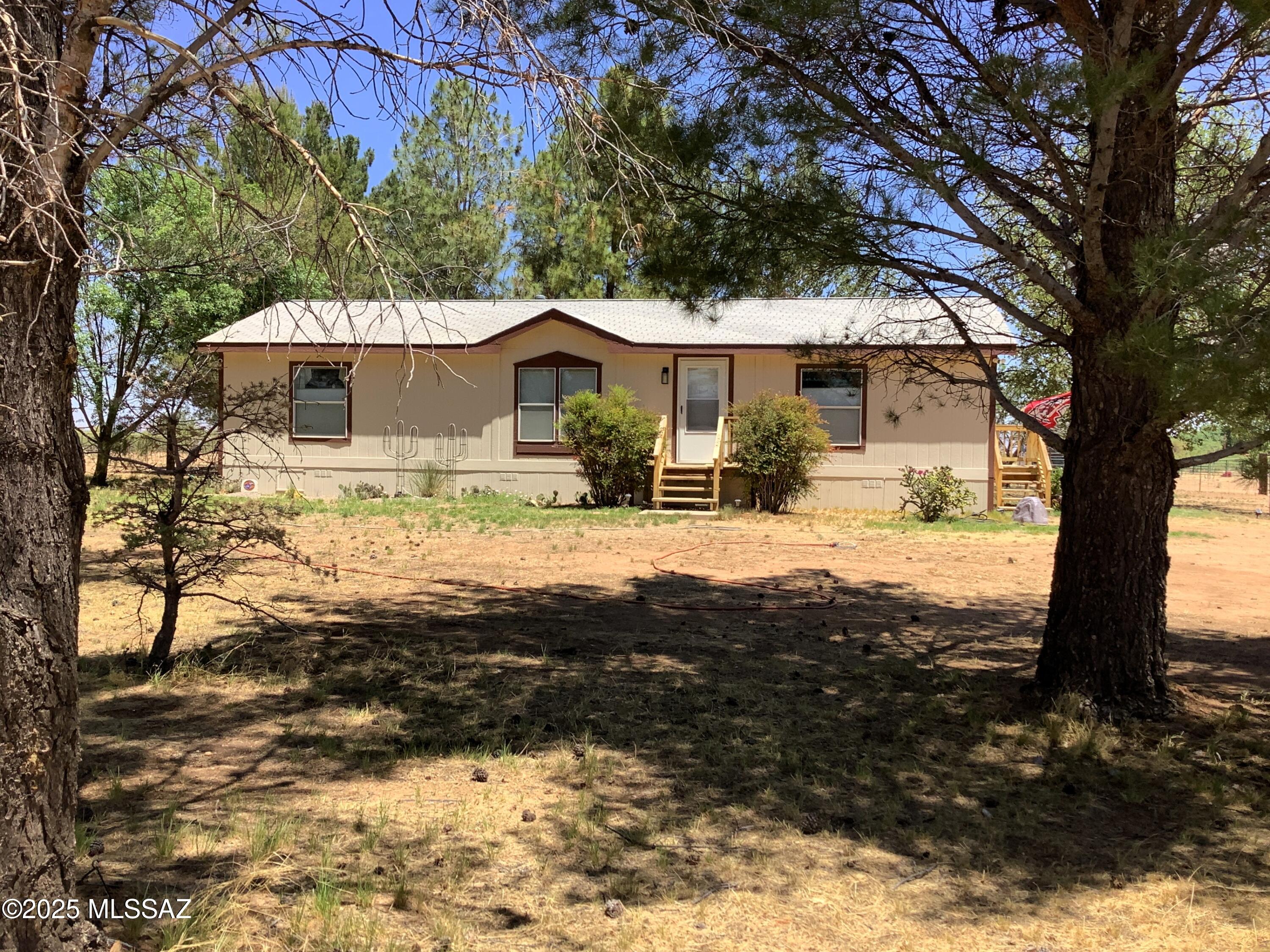 5-acres of horse property with an impressive 3-bed, 2-bath 1248' manufactured home that has lots of upgrades in this recently remodeled home.  It has a beautiful large covered back screened-in porch & animal door that leads to the washing station with fenced backyard. There is a full RV hookup with its own separate septic tank. Beyond that is the fenced/cross-fenced open animal field that has a barn with attached shelter, an additional detached shelter for your horses & animals to love. Gather around the fire pit & enjoy all that this property has to offer with the beautiful mature trees that have a drip line to keep them watered. Watch your animals enjoying the open land while you take in the surrounding peaceful rural area with those gorgeous mountain views, sunrises & sunsets.