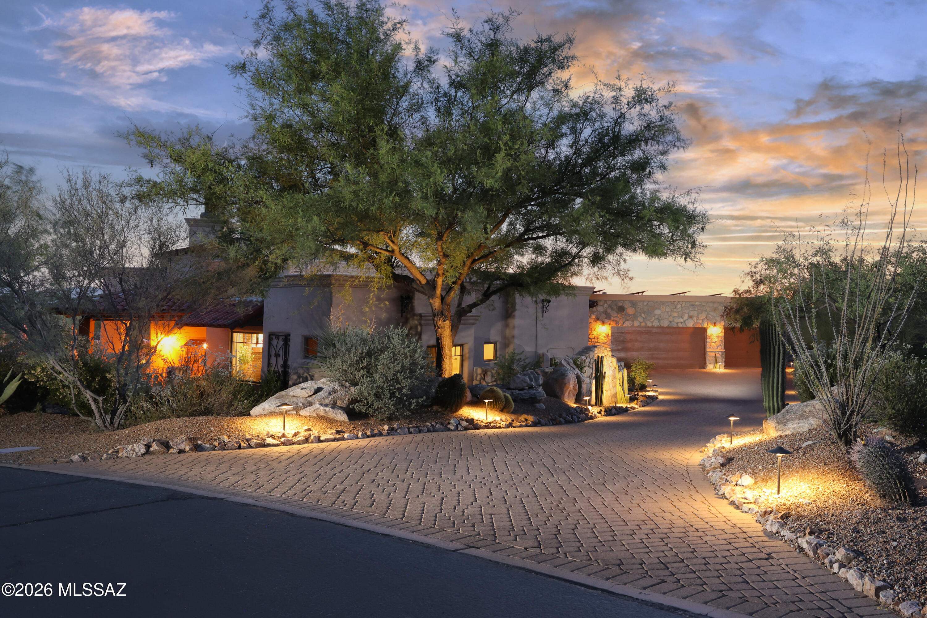 Timeless Tuscan country design creates charming retreat on private cul-de-sac with Catalina views in Stone Canyon, an exclusive guard-gated golf community in Oro Valley. Bordered by stone walls, this beautifully furnished ~3,700 SF custom design (great room, 4 suites, 5BA) melds rustic design with luxury amenities. Arched 9' entry door, Cantera columns, massive Cantera Fpl, inset soffit ceiling with wood beams, Wine Room, Chef's Kitchen (Viking stove, pot filler, 2 D/W, Warming Drwr, M/W, 48'' Ref/Fz, island w/prep sink). French doors lead to brick paver patio, Pool, Spa, Gazebo w/Fpl, Bocce Ball crt, Rooftop deck overlooking acres of open space. Romantic main suite with brick Fpl, spa-like bath (towel warmer, heated floor, TV) & outdoor Sauna. Owned Solar, Big 3-Car Garage. Membership Req