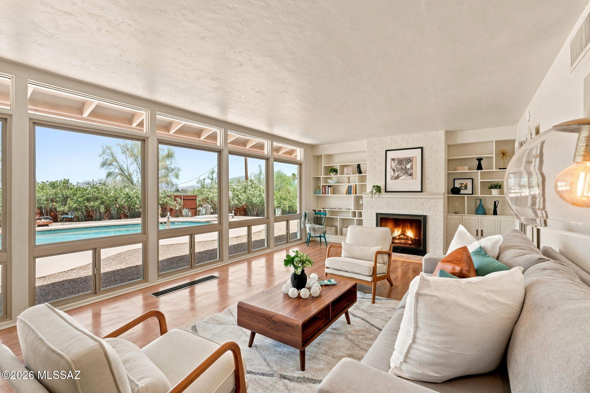 Located within the historic Harold Bell Wright Estates on Tucson's east side, this thoughtfully maintained residence blends timeless mid-century modern character with exceptional privacy and mountain views. Built in 1956, the home offers 1,885 square feet of living space featuring classic whitewashed brick construction, two bedrooms, and two bathrooms. The spacious living room frames stunning views of the Rincon Mountains, overlooking the sparkling pool and expansive backyard beyond. Situated on a generous 0.791-acre lot, the property provides a rare sense of seclusion while remaining conveniently located near shopping, dining, and everyday amenities, with easy access to St. Joseph's Hospital and Tucson Medical Center. Designed to embrace Tucson's outdoor lifestyle, the home features multiple private patio areas ideal for relaxing or entertaining. A rooftop deck crowns the property, offering spectacular 360-degree views of the city skyline, surrounding mountain ranges, and Arizona's unforgettable sunsets. Combining architectural charm, generous outdoor spaces, and a highly sought-after location, this unique property presents a wonderful opportunity to own a piece of Tucson history.