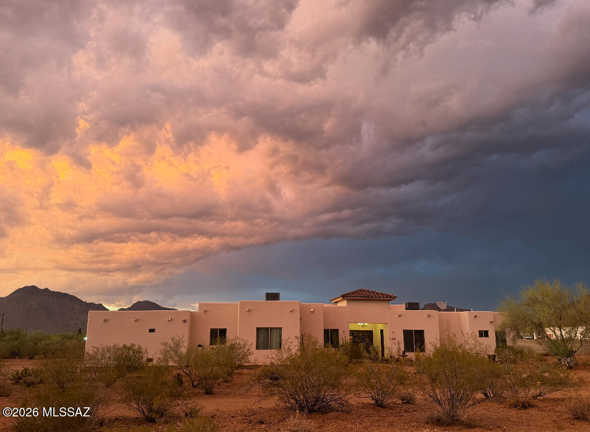 Experience breathtaking mountain views and the beauty of the Sonoran Desert from this exceptional custom Santa Fe-style home. Built in 2021 and thoughtfully positioned on 3.63 private acres, this 3,100-square-foot residence offers the perfect balance of luxury, privacy, and desert living.
Designed with both elegance and functionality in mind, the home features 4 spacious bedrooms, 2.5 bathrooms, and a versatile bonus room ideal for a home office, gym or creative studio with private entrance. Soaring ceilings, abundant natural light, built in sound system and an open-concept floor plan perfect for comfortable living, gathering and entertaining. 

 Walk into the spacious kitchen perfect for all your cooking and hosting needs, complete with striking green cabinetry ample marble countertop space, oversized kitchen island and walk-in pantry.
The spacious primary suite serves as a private retreat with your own private patio space, walk-in closet and spacious bathroom featuring dual vanities and a spa-like ambiance designed for relaxation.
Step outside and discover your own desert sanctuary. Panoramic mountain views, native Sonoran Desert landscape and wildlife.
Zoned Suburban Ranch, this property offers the flexibility to accommodate horses and other animals, making it an ideal opportunity for those seeking a rural lifestyle without sacrificing modern comfort and convenience.