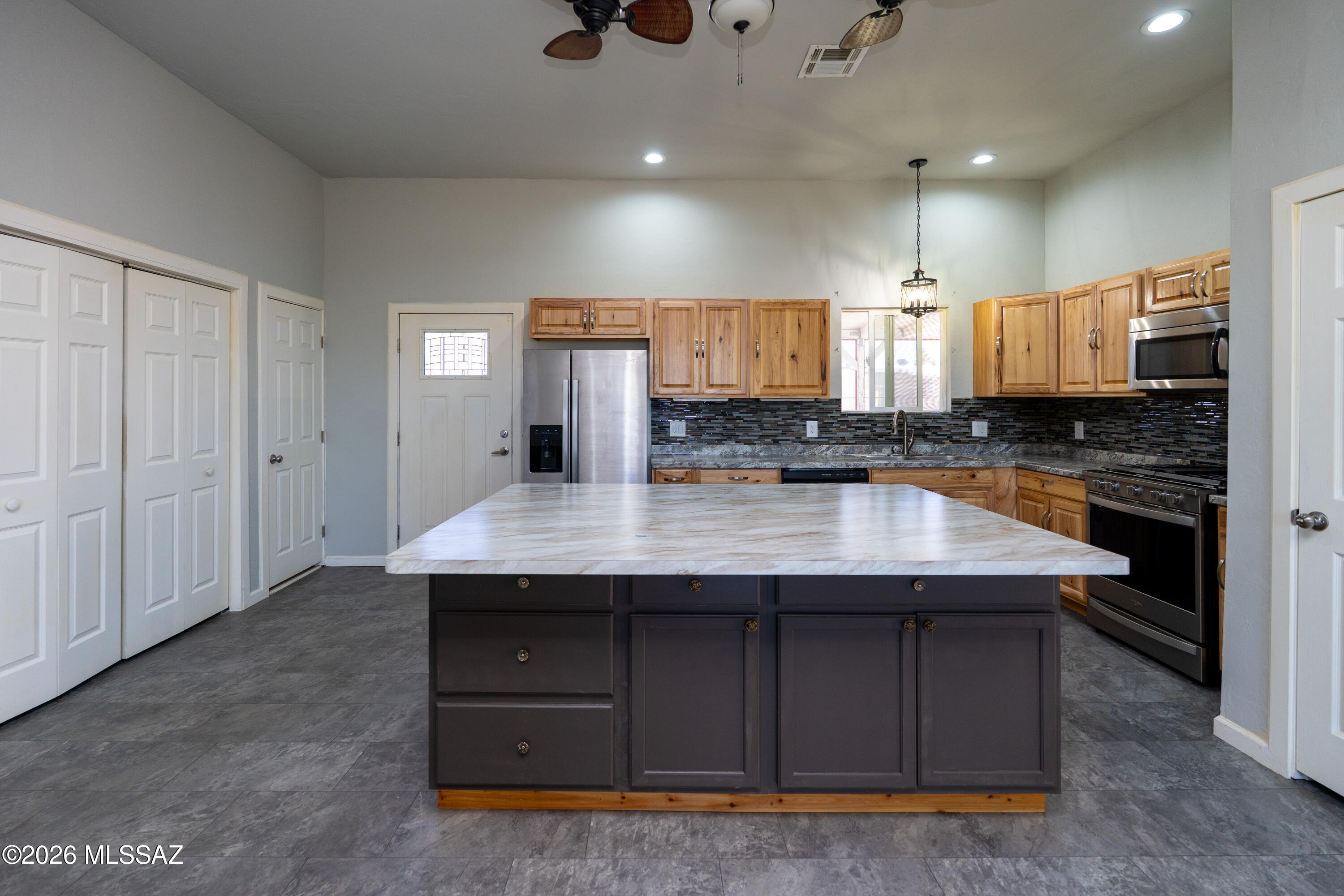 NEWER built 2019! Bright & Open great room floor plan with a desirable split-bedroom layout, offering 3 bedrooms and 2 baths. The spacious kitchen is designed for both function & entertaining, featuring abundant storage, generous counter space, and an OVERSIZED CENTER ISLAND--perfect for entertaining, family get-togethers, cooking, canning, crafts, and more. The large primary suite provides a relaxing retreat with an oversized walk-in shower and a spacious walk-in closet. Step outside to the screened-in patio, complete with an above-ground spa--ideal for enjoying Arizona's beautiful year-round weather. Additional highlights include RV gate access from the alley with ample space for RVs, recreational vehicles, trailers, & toys. Freshly painted, impeccably clean & truly ''Move-In Ready''!