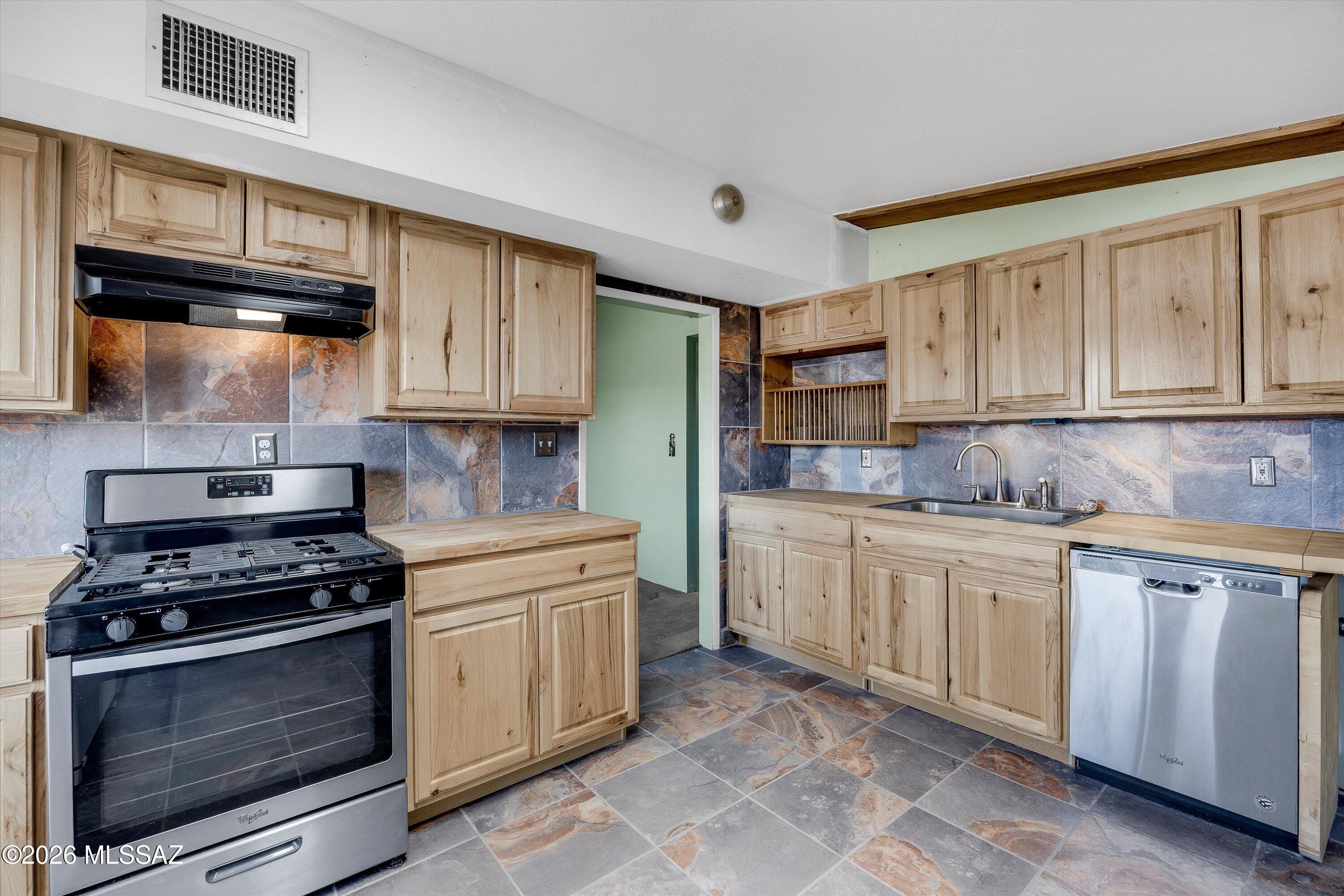 This delightful 1,373 sq. ft. block home features 2 bedrooms and 1 upgraded bathroom, offering a cozy living environment complete with a fireplace and extra storage. The interior is well-appointed with a spacious living area, a combination of ceramic tile and carpeting, and a modernized kitchen featuring dual-pane windows. For added convenience, the home includes a large interior laundry room equipped with a washer and dryer. Outside, the fenced backyard provides a perfect retreat for pets and outdoor activities, showcasing breathtaking mountain views.