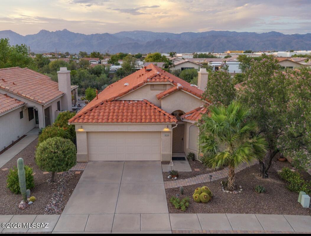 MOVE IN READY home with large backyard featuring an extended paver/brick patio with hot tub and Gazebo, surrounded by desert vegetation, no direct rear neighbor and views of the Catalina mountains. Interior includes upgraded cabinets and granite countertops in kitchen and bathrooms. 20 inch tile flooring throughout the spacious floor plan which offers a large family room with a fireplace, front living room with dining area. Primary bedroom with bay window and mountain views. Primary bath includes a garden tub and separate shower with marble surround. Plantation shutters throughout and solar tube skylights in family room and garage for natural lighting. Updates include roof redone in 2023 and new HVAC system installed in 2021.
