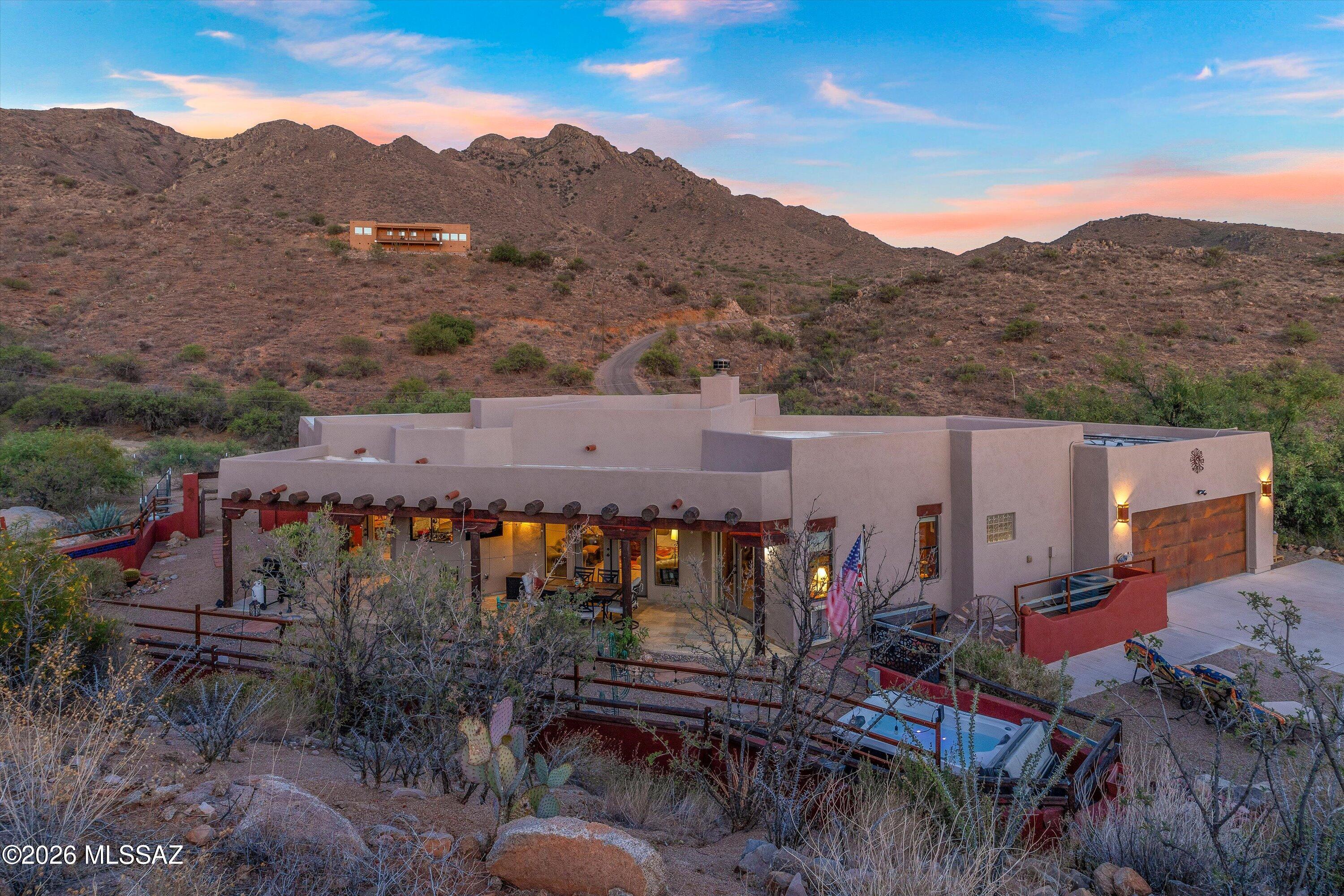 High-tech meets artistic desert serenity in this stunning Rio Rico retreat perched at nearly 4,000 ft elevation and canyon views. Designed for peaceful living, the home features soaring wood-beamed ceilings, a beehive fireplace, split floor plan, multiple patios, and wide-open acreage offering privacy, space, and unforgettable starry nights from the hot tub. The chef?s kitchen includes alder cabinetry, granite countertops, gas cooking, and a huge pantry.  The flexible third bedroom with French doors makes an ideal art studio or guest suite with an adjacent full bath that features dual copper sinks. Fully owned solar, Tesla Powerwall backup, and Starlink high-speed internet combine beauty with modern convenience. workshop garage, fenced yard, nearby hiking trails, Tubac dining, golf, and golf, and galleries complete this unique desert escape.