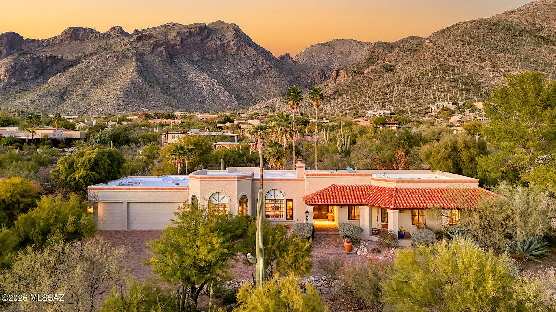 Nestled within the guard-gated enclave of Sin Vacas in the sought-after Catalina Foothills, this exceptional residence is set against a spectacular backdrop of sweeping Catalina Mountain views. A paver circular driveway leads to a grand entrance that immediately draws you inside to stunning interior sightlines, where picture windows frame the scenery from nearly every angle. The open living, dining, and family room areas create an ideal flow for both everyday living and entertaining, complemented by warm wood flooring and numerous interior updates throughout. A versatile recreation room with a built-in bar offers endless possibilities for entertaining or relaxing. The chef's kitchen features stainless steel appliances, a butcher block island, casual eat-in area, and a walk-in pantry. The primary suite is a true retreat with an adjoining officeperfect as a library or private workspacealong with dual vanities, a soaking tub, tiled shower, and a spacious walk-in closet. Three additional guest bedrooms and two baths provide ample accommodations. Outdoors, enjoy a resort-style setting with a pool, fireplace, multiple private seating areas, and breathtaking, seemingly endless views making this homean entertainer's dream and a serene desert escape.