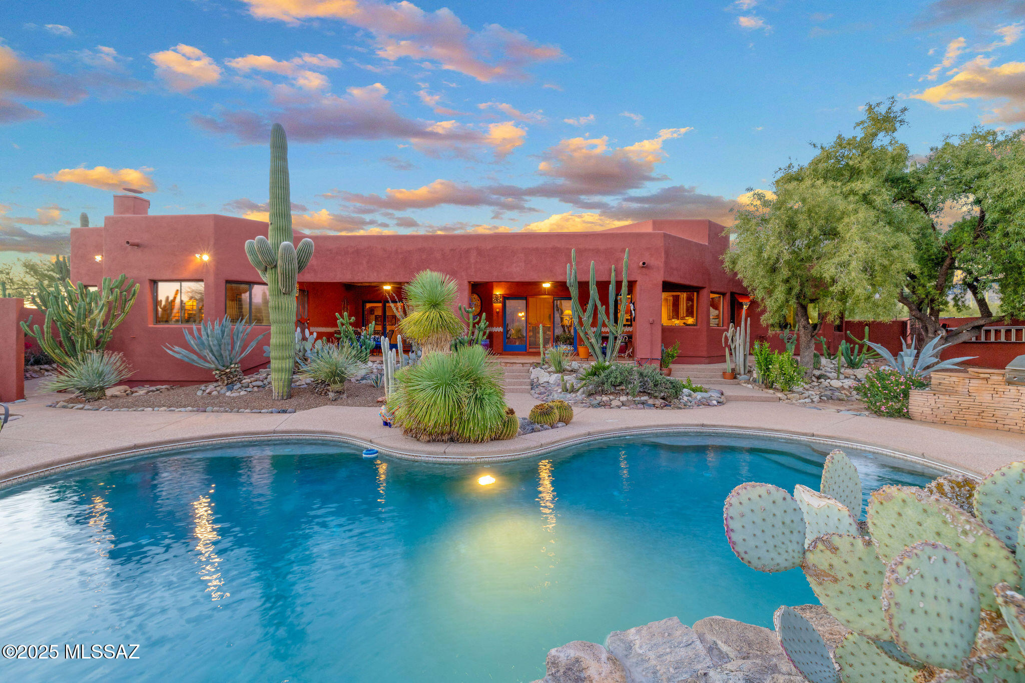 Nestled within the coveted equestrian community of La Cebadilla Estates, this extraordinary Santa Fe residence blends professional artistic Mexican hacienda influences with luxury upgrades and true desert serenity. Perfectly sited on 3.7 acres of tranquility, the home enjoys unobstructed Rincon Mountain views, breathtaking sunrises, and the peaceful lifestyle that makes La Cebadilla so sought-after quiet surroundings, horse-friendly acreage, private riding trails, and access to the community's spring-fed pond.
Stepping inside, you're welcomed by authentic exposed beams and saltillo brick floors that immediately set the tone for warmth, craftsmanship, and character! The inviting great room is anchored by a two-sided fireplace, creating an ideal gathering space that flows effortlessly into the large dining roomperfect for elegant entertaining or cozy evenings at home. Brick detailing and abundant natural light complement the home's rich architectural charm!
The chef's kitchen is a true standout, designed for both culinary enthusiasts and entertainers alike. High-end appliances, an uninterrupted central island, custom cabinetry, a bright breakfast nook, walk-in pantry, and a dedicated coffee bar with built in recycling bin elevate everyday living with style and function.
The expansive primary suite is privately positioned to maximize peace and dramatic desert views. Large windows frame the mountains and mature landscape, creating a calming retreat. The beautifully updated spa-like bathroom offers elevated finishes, generous counter space, a walk-in shower, and a tranquil ambiance ideal for unwinding at the end of the day. Guest bedrooms are equally inviting, with big windows capturing mountain vistas and updated bathrooms featuring custom mosaic tile work. Each bedroom includes a custom closet system for thoughtful organization.
Outdoor living is resort-like and designed to embrace Arizona's beauty. A deep covered patio invites dining, lounging, and sunset watching, while the sparkling pool and lush, mature desert landscaping enhance the home's private oasis feel.
For equestrian lovers, the property is a dream: a 60x36 custom barn accommodating 3+ stalls, durable interior construction, hay racks, and dividers, plus a riding arena and turnout area with direct access to trails leading toward the wash and onward to Saguaro National Park. Whether for casual riding or training, the setting is exceptional.
Peace of mind comes from significant system upgrades: polybutylene plumbing replaced, owned solar system delivering low-to-no electric bills, a refreshed roof, and two new AC units recently installed by the sellers. A three-car garage with an adjoining workshop area provides excellent space for tools, hobbies, or equestrian gear.
A true estate-grade offering, this home embodies the essence of La Cebadilla livingprivacy, natural beauty, equestrian amenities, and a residence filled with artistry, character, and pride of ownership. Properties with this level of charm, upgrades, acreage, and location are exceptionally rare. Welcome Home!