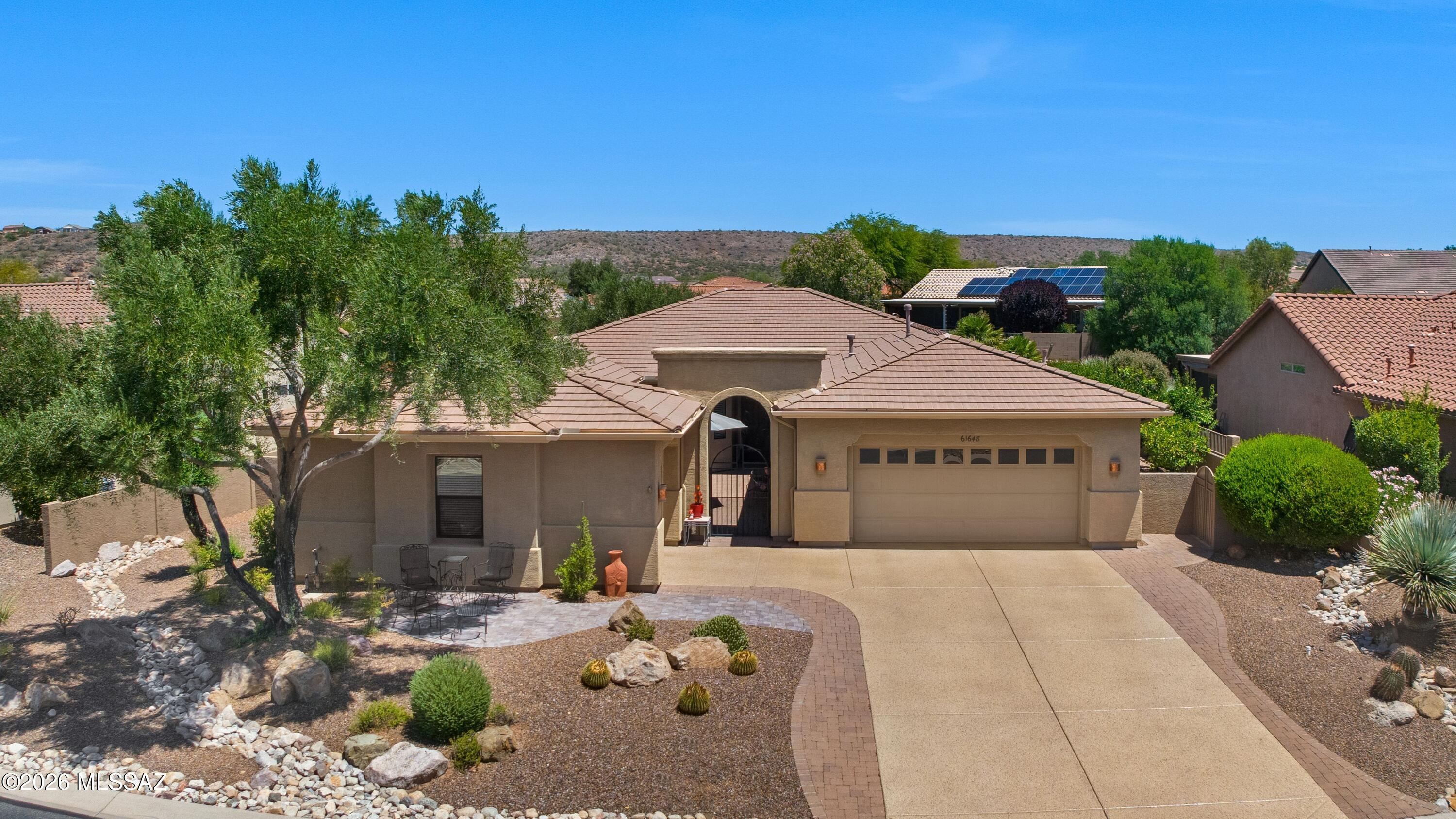 Cimarron with Guest House with mountain views from front & backyard! Inviting paver courtyard leads to front entry door. Great Room features dining area & patio slider. Kitchen offers Quartz counters, stainless appliances, gas cooktop, island, natural cherry cabinets, & breakfast nook. Den with French doors. Owner's Suite includes patio slider & en-suite bath with Quartz vanities, walk-in shower & walk-in closet. Guest bedroom has walk-in closet with adjacent guest bath. Laundry Room has 2025 W/D & cabinets. Guest House has Murphy bed system, closet, & full bath. 2-car garage has 2-2020 HVAC's, 2019 W/H, cabinets, attic stairs, lift, & 2024 Nuvo water filtration system. Separate 1-car garage has mini-split & person door. Covered patio, ext. paver patio, lovely landscaping & gated yard!