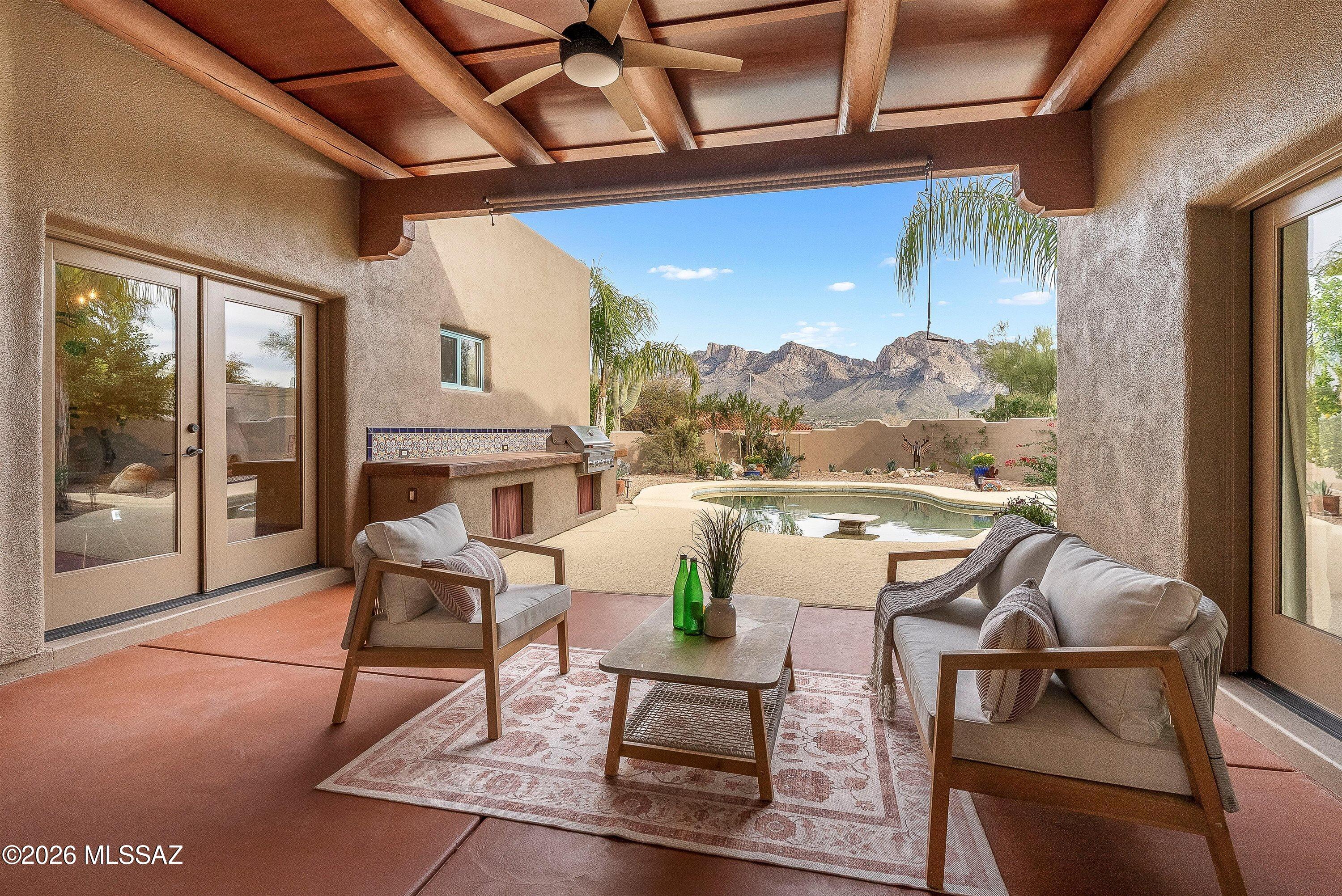 Discover refined luxury in this stunning custom residence, perfectly positioned on a serene, low-traffic cul-de-sac within the prestigious gated community of Cañada Hills Estates. Set on an expansive 0.68+ acre lot with direct golf course access and breathtaking Catalina Mountain views, this meticulously remodeled 4-bedroom, 3-bath home with den/office and 3-car garage embodies the essence of sophisticated Southwestern living.
This home showcases exceptional architectural character throughout. Exposed wood viga beams, custom solid-wood doors with distinctive wrought-iron hardware and decorative grillwork welcome you into spaces filled with natural light. The warm terracotta Saltillo tile flooring flows seamlessly throughout the main living areas, complemented by accent borders.The completely reimagined chef's kitchen is a culinary masterpiece featuring premium stainless steel appliances, gleaming granite countertops with natural movement and character, and rich 42" solid wood cabinetry with custom wrought-iron hardware. The large center island boasts a professional 6-burner gas cooktop, additional prep sink, and dramatic architectural hood. An oversized walk-in pantry, dual wall ovens, and a sun-drenched breakfast nook with mountain views complete this entertainer's dream. A custom wet bar area features vibrant hand-painted Mexican Talavera tiles in terra cotta and turquoise tones with intricate decorative patternsperfect for entertaining.
The open floor plan flows effortlessly from the generous great roomanchored by a sculptural Southwestern-style beehive fireplace with terra cotta surroundto the formal dining room featuring soaring ceilings accented with exposed vigas and wrought-iron chandeliers. The separate formal living room provides an additional sophisticated gathering space bathed in natural light.
Retreat to the tranquil primary suite, a private sanctuary featuring a luxurious spa-inspired ensuite bath with a modern soaking tub, frameless glass walk-in shower with designer vertical tile accent, an expansive walk-in closet, and serene views overlooking your backyard oasis and the Catalina Mountains.
The backyard is an entertainer's dream showcasing exceptional craftsmanship and stunning sunset and mountain vistas. The expansive covered patio features a custom-built outdoor kitchen and BBQ area adorned with custom, vibrant hand-painted Mexican Talavera tiles. A stunning designer beehive kiva fireplace with matching custom Mexican tilework creates an intimate gathering spot. The sparkling pebble tech pool with decorative tile accents, and multiple lounging areas invite year-round enjoyment under Arizona's iconic skies. Low-maintenance desert landscaping with mature citrus trees and native plantings frame the space beautifully.
The guest bathroom showcases more spectacular custom Mexican tile work. 
Unbeatable Location & Lifestyle
Golf Course Living: Direct access to championship golf year-round with scenic fairway views
Active Lifestyle: Steps to The Tucson Loop137 miles of paved trails for biking, walking, running, and skating
Walkable Amenities: Starbucks, artisan bakery, acclaimed local restaurants, Pilates studio, and library all within strolling distance
Recreation: Naranja Park, Catalina State Park, and Oro Valley Recreation Center nearby offering fitness classes, pickleball courts, tennis courts, golf lessons, and endless hiking opportunities.
Secure Community: Gated entry with very low HOA fees
Impeccably maintained and thoughtfully updated throughout, this rare offering combines privacy, functionality, and timeless Southwestern design. Experience the perfect balance of tranquil desert living with unparalleled convenienceall within a secure gated community with mountain views that take your breath away