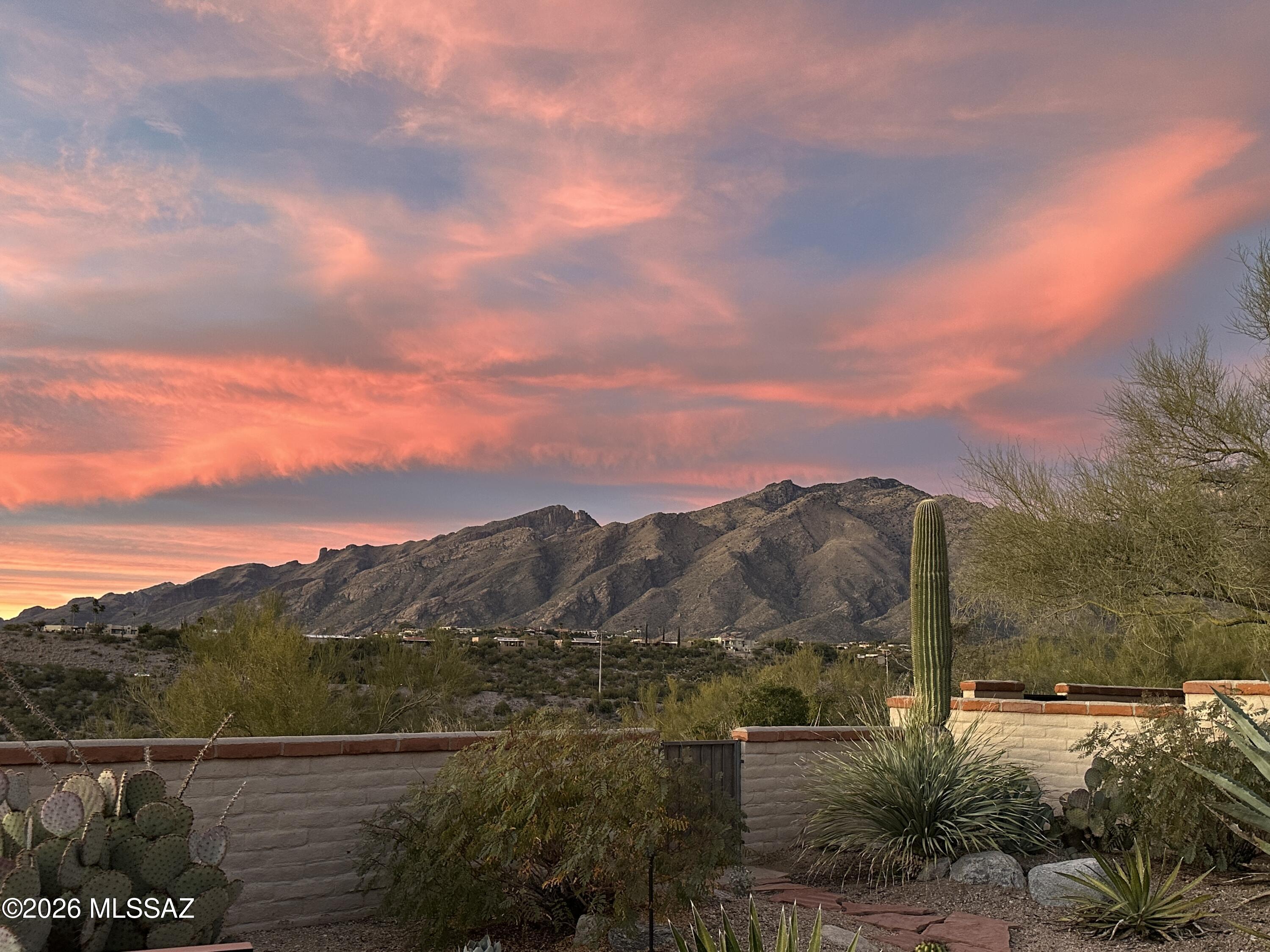 Ridgeline Townhome with Unparalleled Views

Nestled in the highly sought-after Sunrise Ridge Townhomes within the prestigious Fairfield community in Tucson's Foothills, this beautifully updated, open concept 1,659 sqft Townhome offers 2beds, 2 baths, and truly extraordinary panoramic views spanning the entire Tucson Valley. From the majestic Catalina Mountains, the Tucson Mountains, the Santa Rita Mountains and beyond,  the ever-changing scenery is simply breathtaking. Enjoy sweeping city-light views and iconic Tucson landmarks, including A Mountain, Cat Mountain, and even Kitt Peak on clear days. Multiple covered patios provide the perfect setting to experience unforgettable Arizona sunsets, expansive mountain vistas, and the sparkling lights of the valley below. Gorgeous natural stone flooring extends throughout the entry, kitchen, hallways, both bedrooms, and bathrooms, while the spacious living and dining areas are appointed with premium neutral carpeting that adds warmth and comfort. A calm, neutral color palette throughout creates a timeless, move-in-ready interior, complemented by numerous new insulated window panes that enhance energy efficiency and provide crystal-clear views. The updated kitchen features warm knotty alder custom DeWils cabinetry with convenient pull-out shelves, granite countertops, elegant glass-front upper cabinets, and abundant storage. Adjacent to the kitchen, a bright and versatile flex space is ideal as a breakfast nook, family room, home office, or hobby room. Perfect place to enjoy a morning coffee and a view. 
The spacious living and dining area is centered around a cozy gas fireplace and enhanced by two double-pane sliding glass doors that open to separate covered patios, seamlessly blending indoor and outdoor living while framing the home's spectacular mountain and city views.
The generous primary suite offers direct patio access, abundant closet space, and a peaceful retreat where you can wake up each morning to the stunning scenery. Both updated bathrooms feature beautifully crafted custom tile surrounds and KraftMaid cabinetry adding style and sophistication. Unlike the standard floor plan, the guest bedroom was thoughtfully expanded, creating an exceptionally spacious and versatile room with two closets and ample space for two beds, a comfortable sitting area, or a combined guest room and home office.
 An oversized garage with built-in storage closets adds exceptional convenience and functionality.
Residents enjoy outstanding HOA amenities, including a community pool and spa, tennis courts, beautifully maintained common areas, street maintenance, and trash service. Convenient guest parking is located just steps from the home.
Ideally located just minutes from premier shopping, fine dining, championship golf, and some of Tucson's most scenic hiking trails, this move-in-ready Foothills retreat also offers the peace of mind of a new roof (2022), a new HVAC system (2023), new Water heater and an on-Demand one under kitchen sink (2025), and New dual window panes (2026). 
Combining one of the Foothills' most expansive mountain and city panoramas with quality finishes, thoughtful updates, exceptional amenities, and a premier location, this is a rare opportunity to own one of Tucson's truly exceptional view properties.