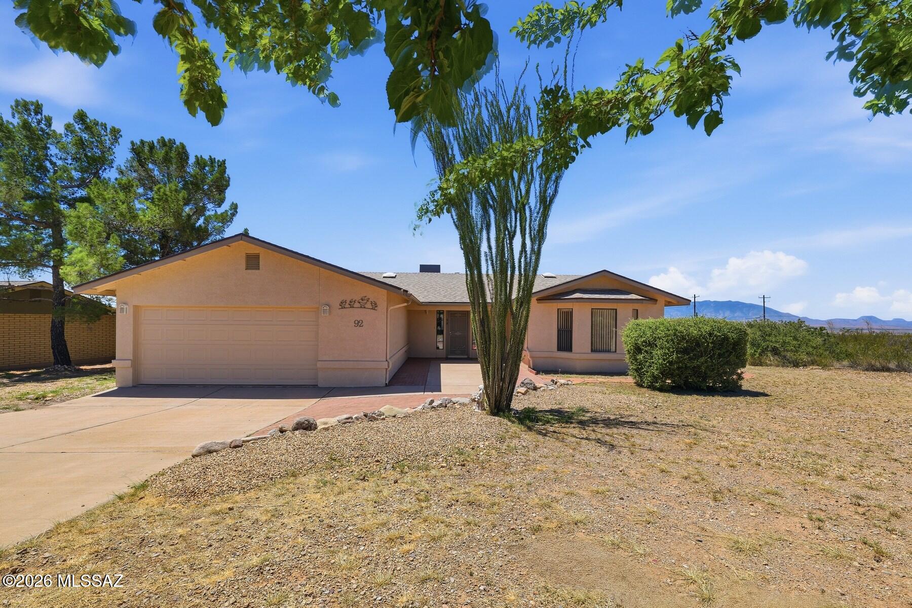 Enjoy breathtaking mountain views from this wonderful 3BR/2BA home on 1.763 acres at the end of a quiet cul-de-sac in Bisbee. A welcoming brick-lined entry leads to a wonderful living space featuring gorgeous flooring and a cozy gas fireplace. The spacious kitchen offers abundant cabinetry and counter space, a gas range, and adjoins the dining area with more spectacular views. The primary suite features a bay window, walk-in closet, and ensuite bath with raised garden tub and separate shower. The stunning Arizona Room showcases walls of glass, a wood ceiling, and custom automatic shades, opening to a wraparound deck perfect for relaxing or entertaining. Complete with two large storage sheds, mature landscaping, natural grass, owned solar, a 2-car garage, and Tesla EV charging station.