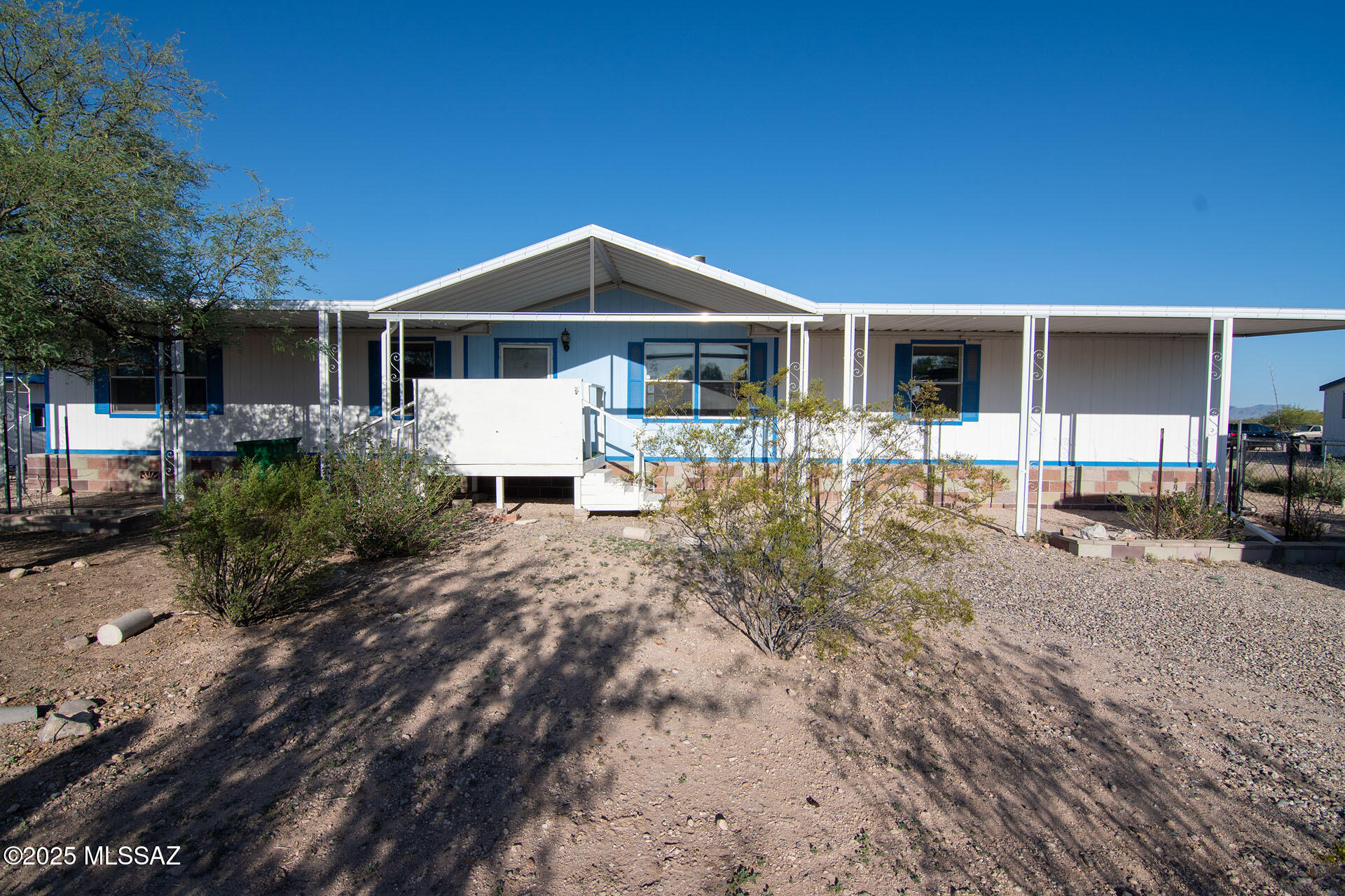 ***Motivated Seller*** Enjoy space, flexibility, and semi-rural living on this full-acre property featuring a spacious 4-bedroom, 2-bath manufactured home with over 2,000 sq ft. The open layout offers abundant natural light, recent interior paint, updated flooring in select areas, and a double-sided wood-burning fireplace. Relax on the covered front porch or spacious screened rear porch for additional year-round outdoor living space. The property includes three outbuildings, including a workshop with electricity, AC, and heat, plus two dedicated garden areas, one fully enclosed. Enjoy room to spread out, stargazing, and frequent visits from many bird species, including quail, while remaining conveniently located just minutes from the freeway and Tucson amenities. Zoning may allow for an additional home on the lot; buyer to verify.