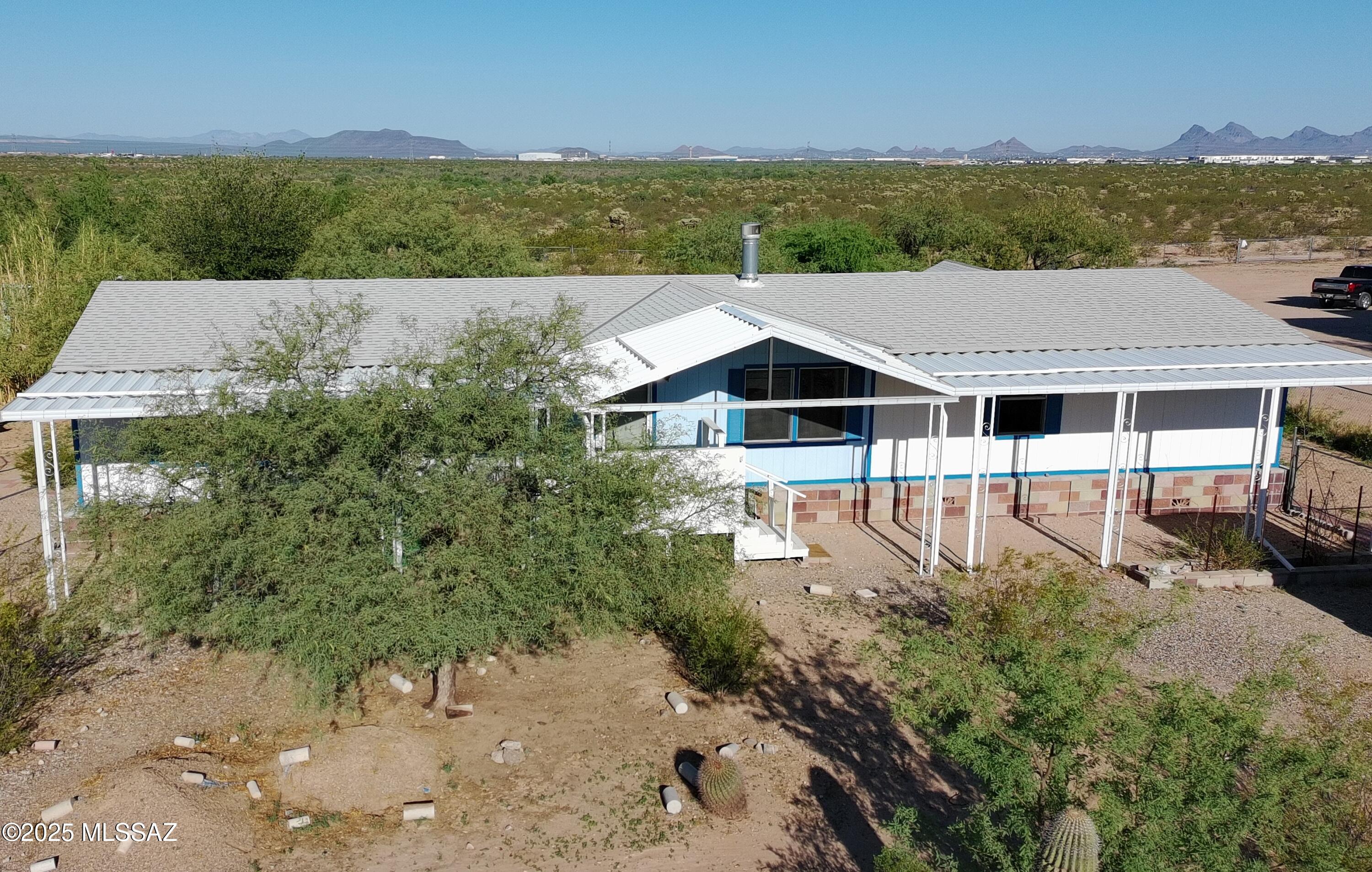***Motivated Seller*** Enjoy space, flexibility, and semi-rural living on this full-acre property featuring a spacious 4-bedroom, 2-bath manufactured home with over 2,000 sq ft. The open layout offers abundant natural light, recent interior paint, updated flooring in select areas, and a double-sided wood-burning fireplace. Relax on the covered front porch or spacious screened rear porch for additional year-round outdoor living space. The property includes three outbuildings, including a workshop with electricity, AC, and heat, plus two dedicated garden areas, one fully enclosed. Enjoy room to spread out, stargazing, and frequent visits from many bird species, including quail, while remaining conveniently located just minutes from the freeway and Tucson amenities. Zoning may allow for an additional home on the lot; buyer to verify.