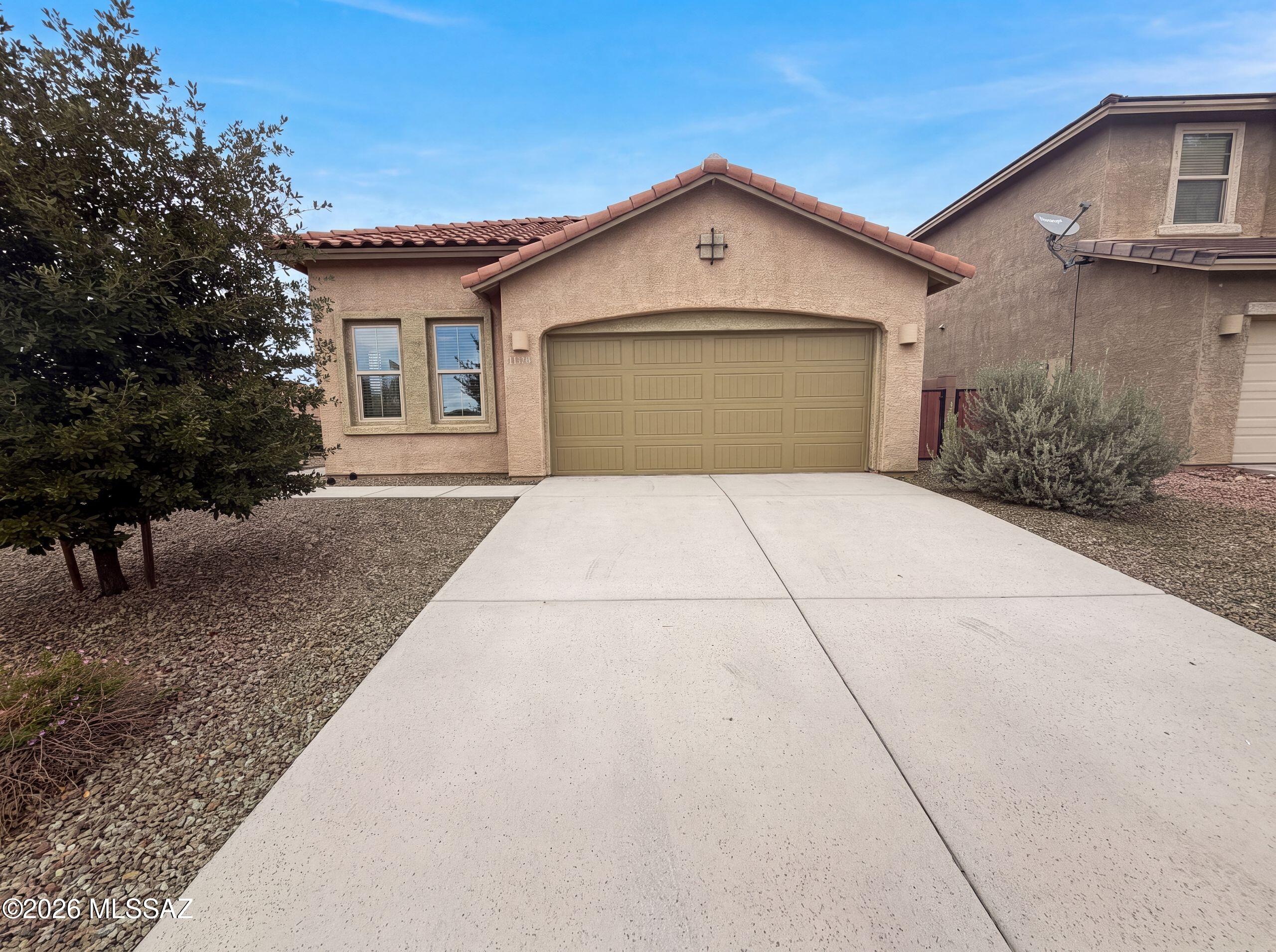 11339 E Glowing Sunset Dr is a one-story Tucson home built in 2016 with an open, single-level layout. The kitchen includes a center island, granite countertops, and stainless steel appliances, flowing into the adjacent great room for connected living. The primary bedroom offers a carpeted retreat with an ensuite bathroom that features a double-sink vanity and a tiled walk-in shower for everyday functionality. Additional bedrooms provide comfortable proportions with ceiling fans and closet storage. A covered patio overlooks the fully fenced backyard, creating a defined space for outdoor use in the desert setting. A two-car garage adds storage and flexibility, and clean interior finishes complete this well-maintained residence with practical amenities in every room.. Included 100-Day Home W