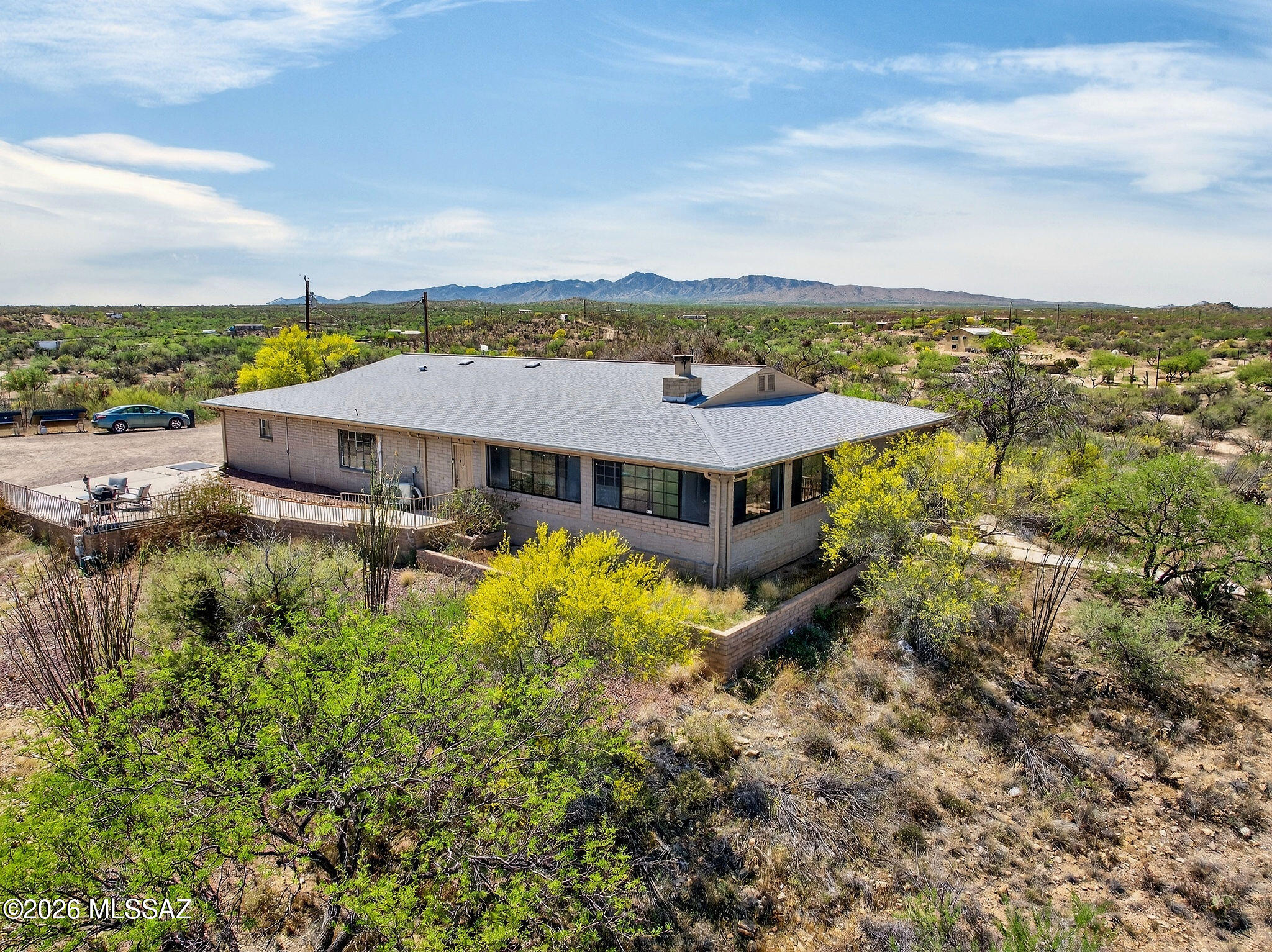 Situated on an expansive 8.77-acre homesite, this private property captures sweeping 360-degree mountain and city views, offering a true desert oasis setting.
The property features an attached two-car garage (approx. 462 sq ft) with built-in cabinetry, a 308 sq ft workshop or studio space (not include in total sf), AND an additional detached four-car garage (approx. 618 sq ft) with electrical - ideal for hobbyists, storage, or additional workspace!
Offering 2,654 sq ft, this ranch-style residence offers a flexible floor plan including the fully enclosed wraparound Arizona room creating additional indoor-outdoor living and a versatile space.
The kitchen, which features multiple skylights, extensive cabinetry and counter space, a built-in desk area, and a center island with seating opens into the spacious living room featuring a cozy wood-burning fireplace.

The dining area has a large window and built-in cabinetry, offering the flexibility to be a home office if desired. The home includes three bedrooms, two bathrooms, including a hot tub in the guest bath.

Enjoy tons of outdoor space and plenty of room for your vehicles and toys. RV parking with cleanout. No HOA restrictions!
Enjoy peaceful mornings with coffee on the front patio or unwind under the covered ramada--both are perfectly positioned to take in the stunning panoramic views any time of the day!